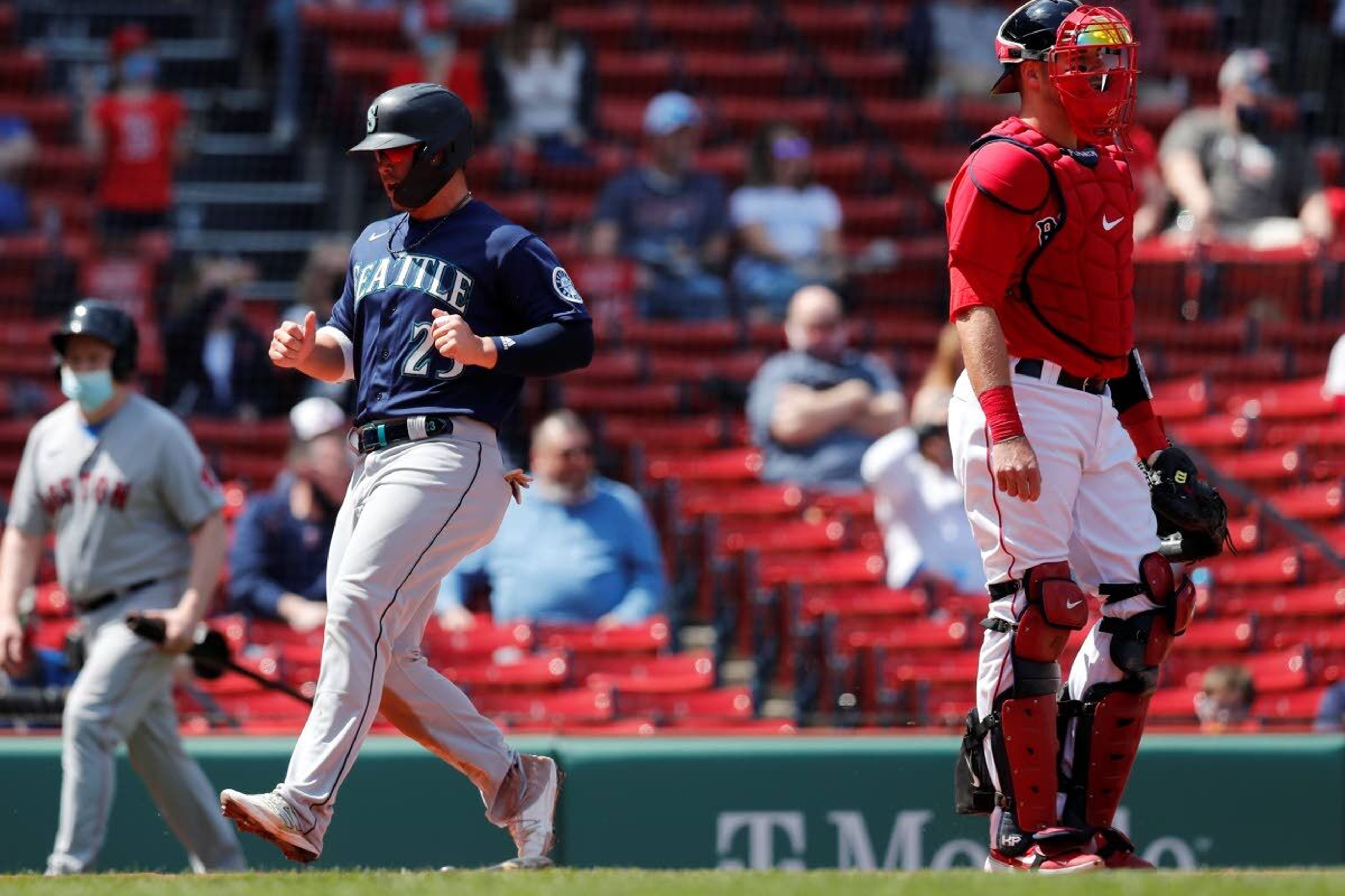 Seattle Mariners' Ty France (23) scores behind Boston Red Sox's Kevin Plawecki on a two-run triple by Kyle Seager during the second inning of a baseball game, Saturday, April 24, 2021, in Boston. (AP Photo/Michael Dwyer)