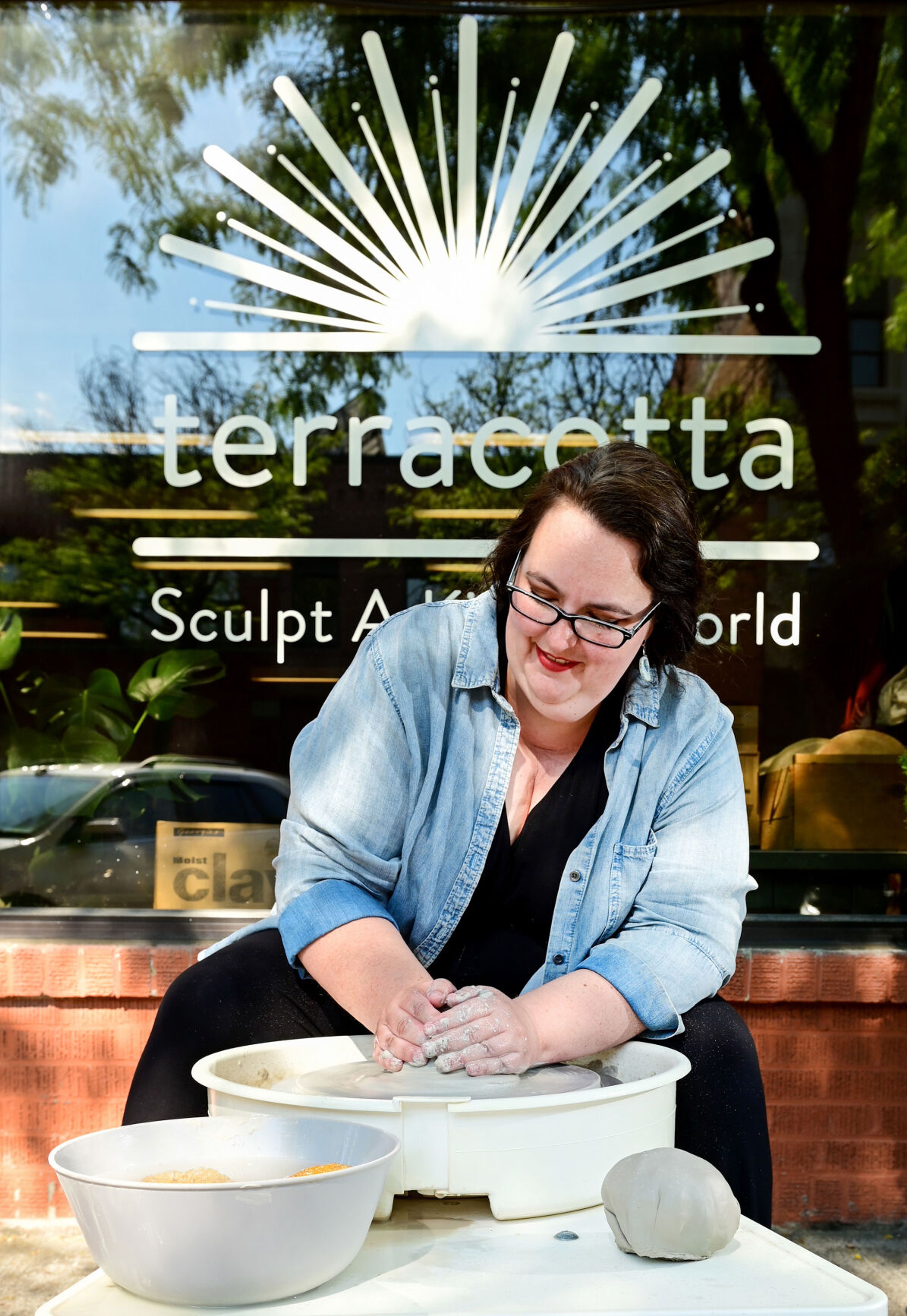 Owner and founder Candace Baltz creates forms wet clay on a potter's wheel on Wednesday outside of Terracotta’s new downtown Moscow space.