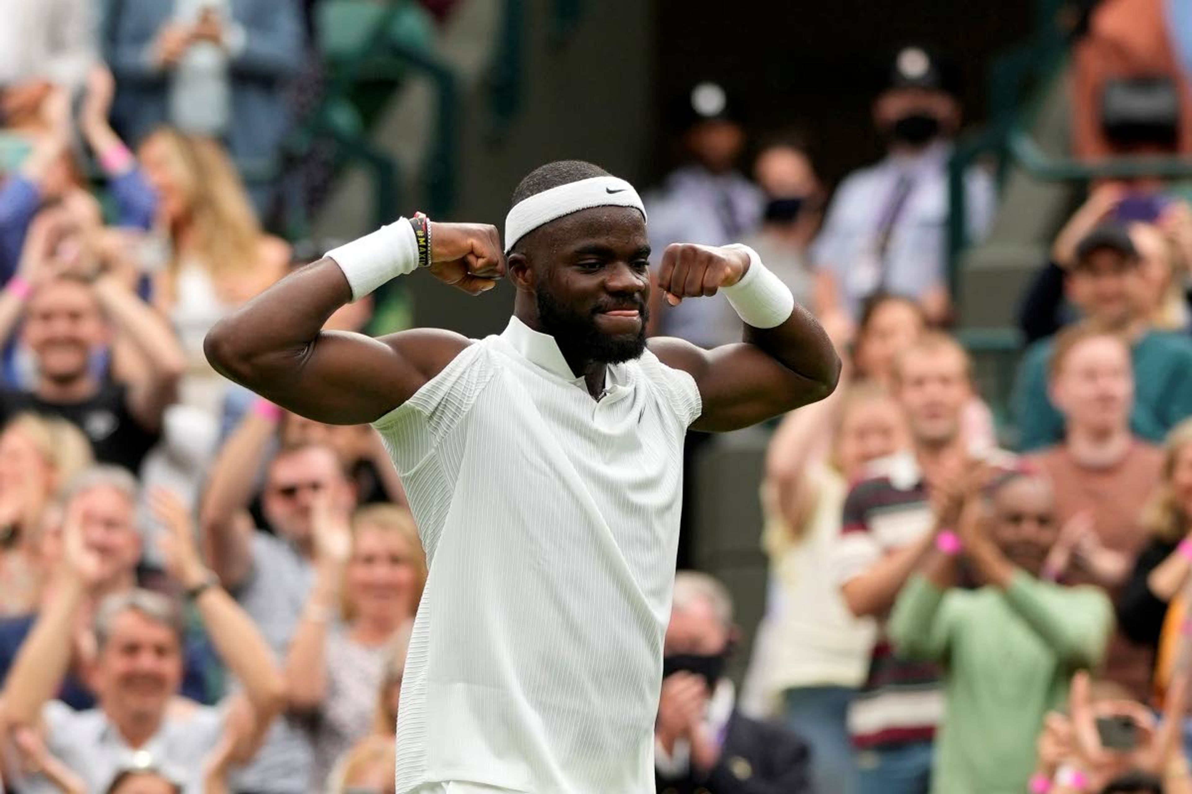 Frances Tiafoe of the US celebrates after winning the men's singles match against Stefanos Tsitsipas of Greece on day one of the Wimbledon Tennis Championships in London, Monday June 28, 2021. (AP Photo/Alastair Grant)