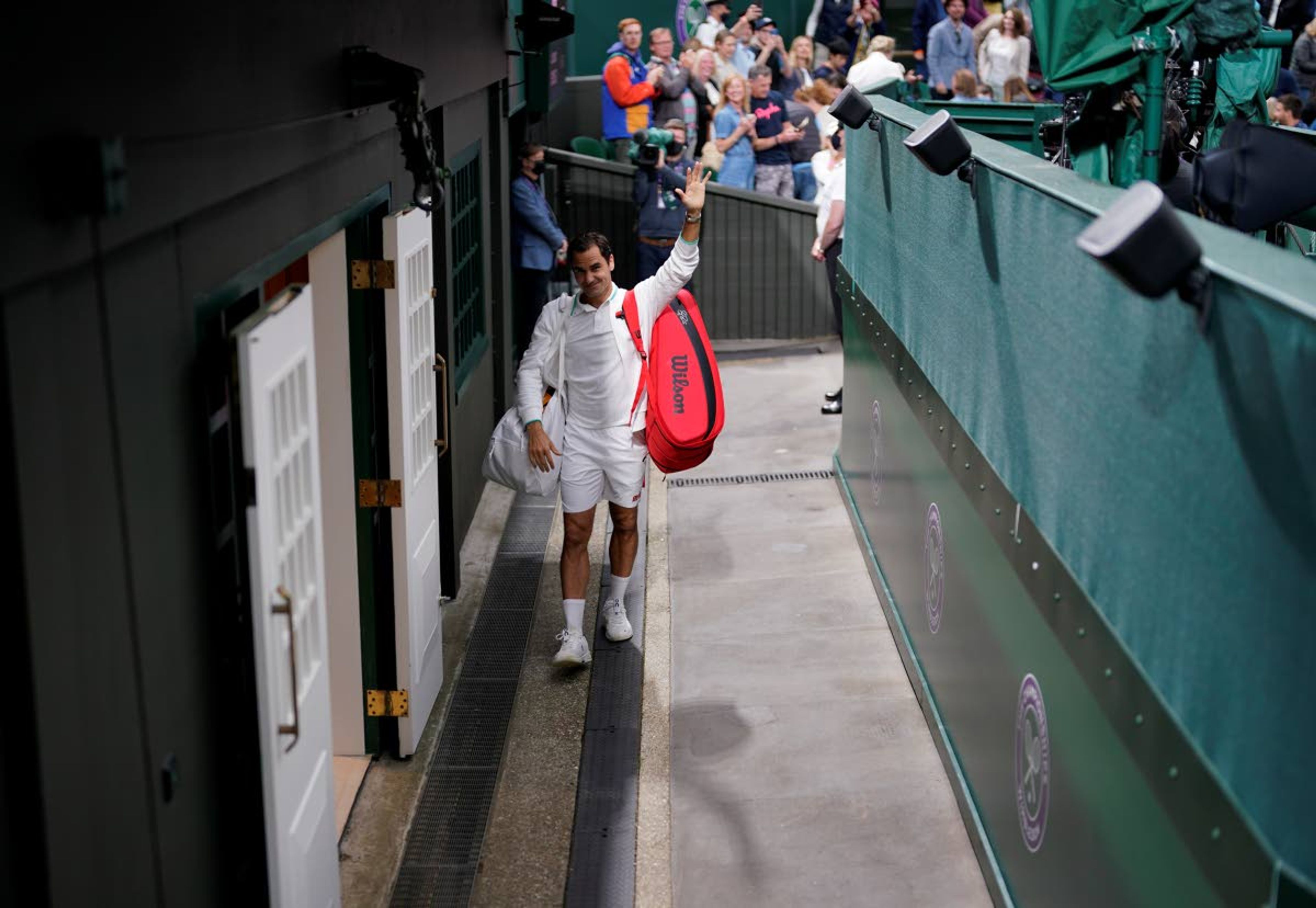 Switzerland's Roger Federer leaves Centre Court after defeating Italy's Lorenzo Sonego during the men's singles fourth round match on day seven of the Wimbledon Tennis Championships in London, Monday, July 5, 2021. (AP Photo/Alberto Pezzali)