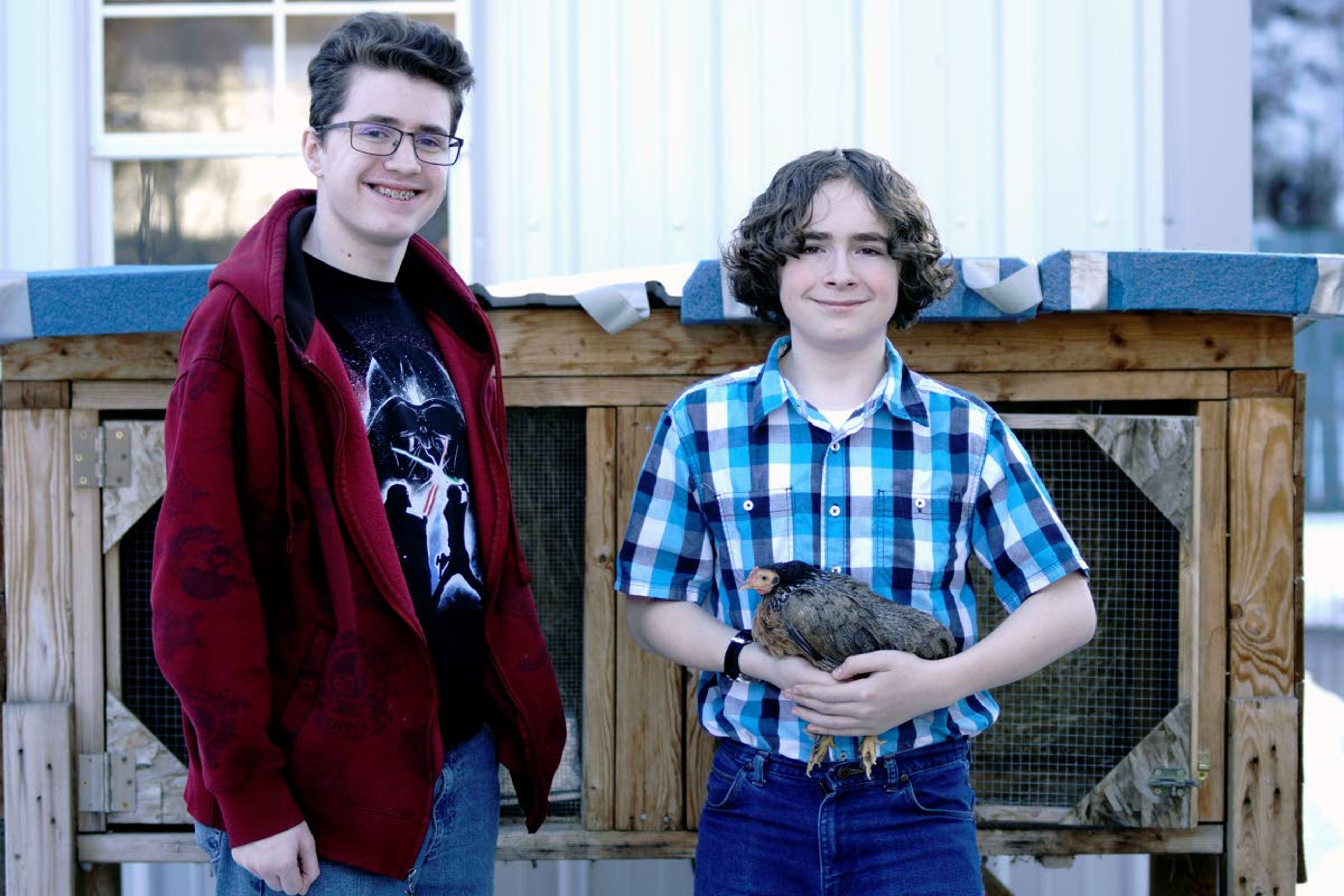 Kevin Lassiter, left, and Charles Lassiter pose with Roani, a 12-year-old Americano Bantam hen.