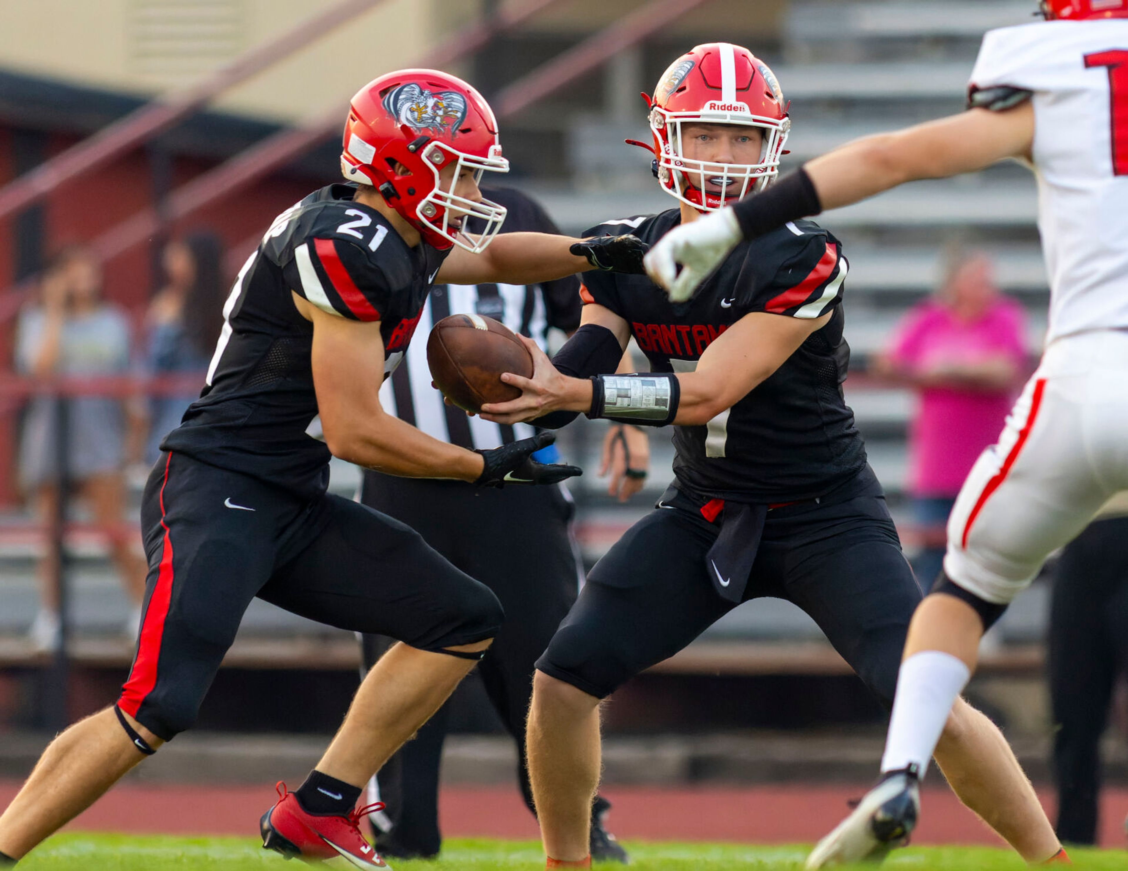 Clarkston quarterback Hayden Line, right, hands the ball off to running back Milo Kunnap during a game against the Moscow Bears on Friday in Clarkston.