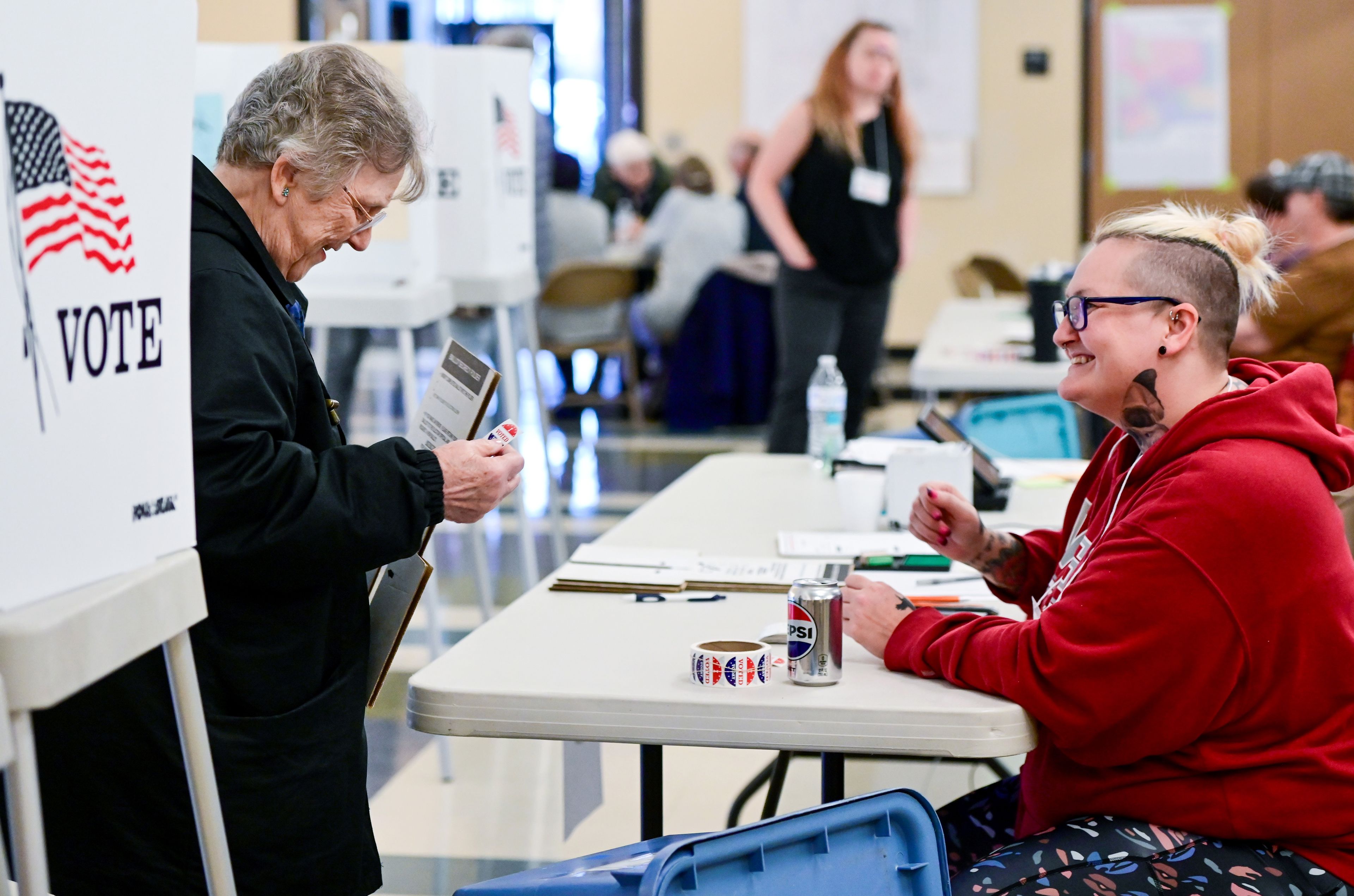 Marva McCoy, left, receives a sticker from elections clerk Nicole Fisher after voting at the Hamilton Indoor Recreation Center in Moscow on Election Day.