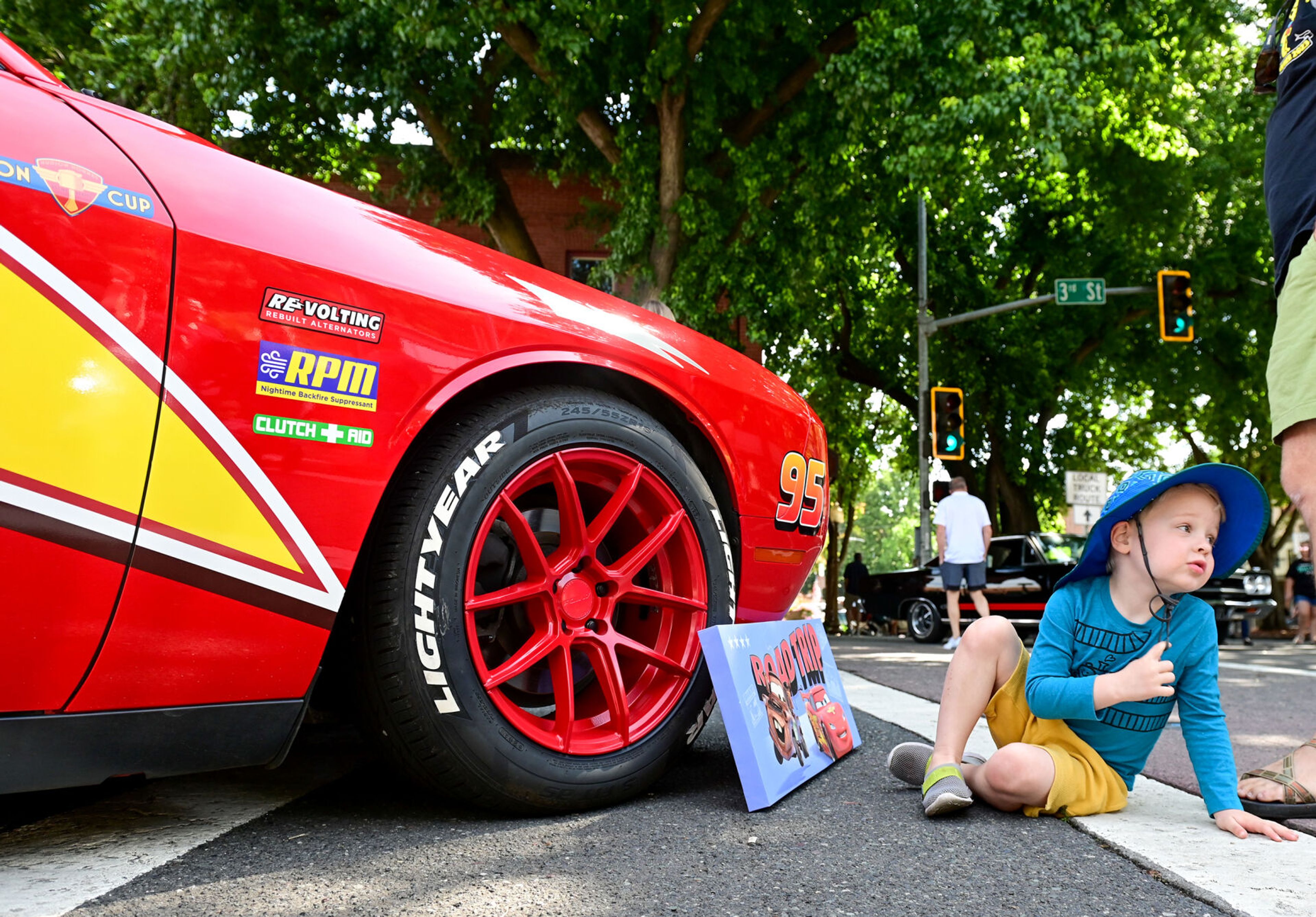 Eli, 3, sits next to a 2015 Dodge Charger detailed to look like Lightning McQueen from Cars at the Lewiston Hot August Nights on Saturday.