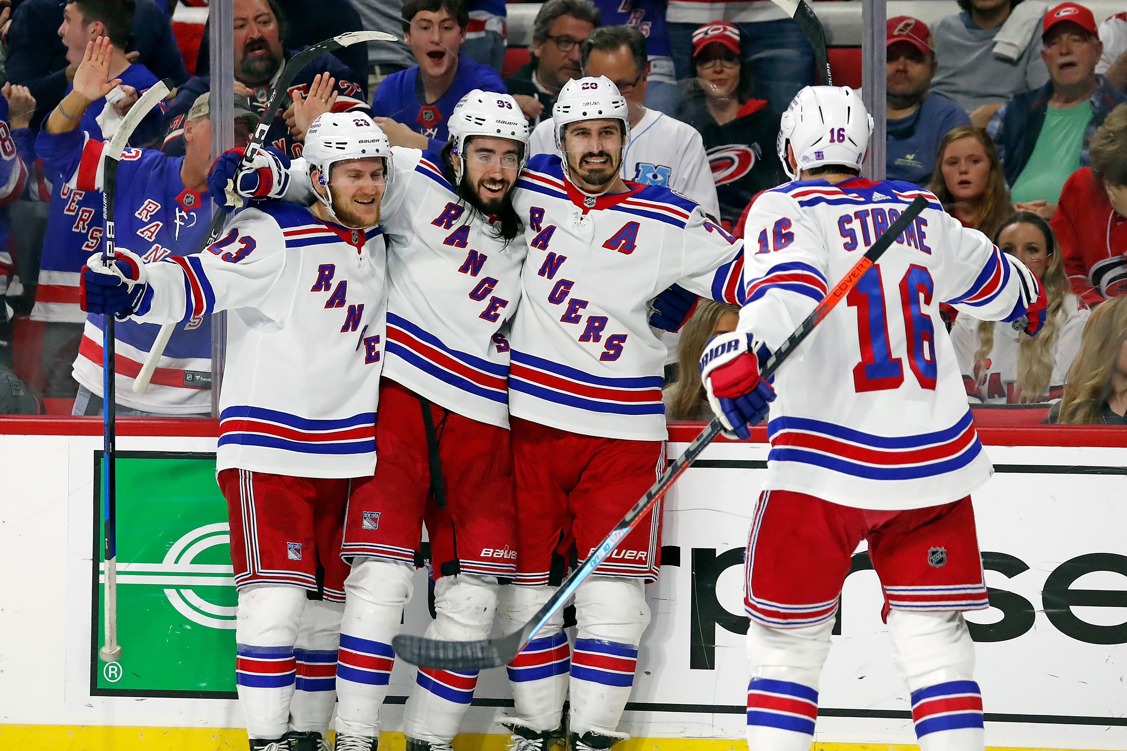 The New York Rangers' Adam Fox (23), Mika Zibanejad (93), Chris Kreider (20) and Ryan Strome (16) celebrate a goal by Kreider during the first period of Game 7 of an NHL hockey Stanley Cup second-round playoff series against the Carolina Hurricanes in Raleigh, N.C., Monday, May 30, 2022. (AP Photo/Karl B DeBlaker)