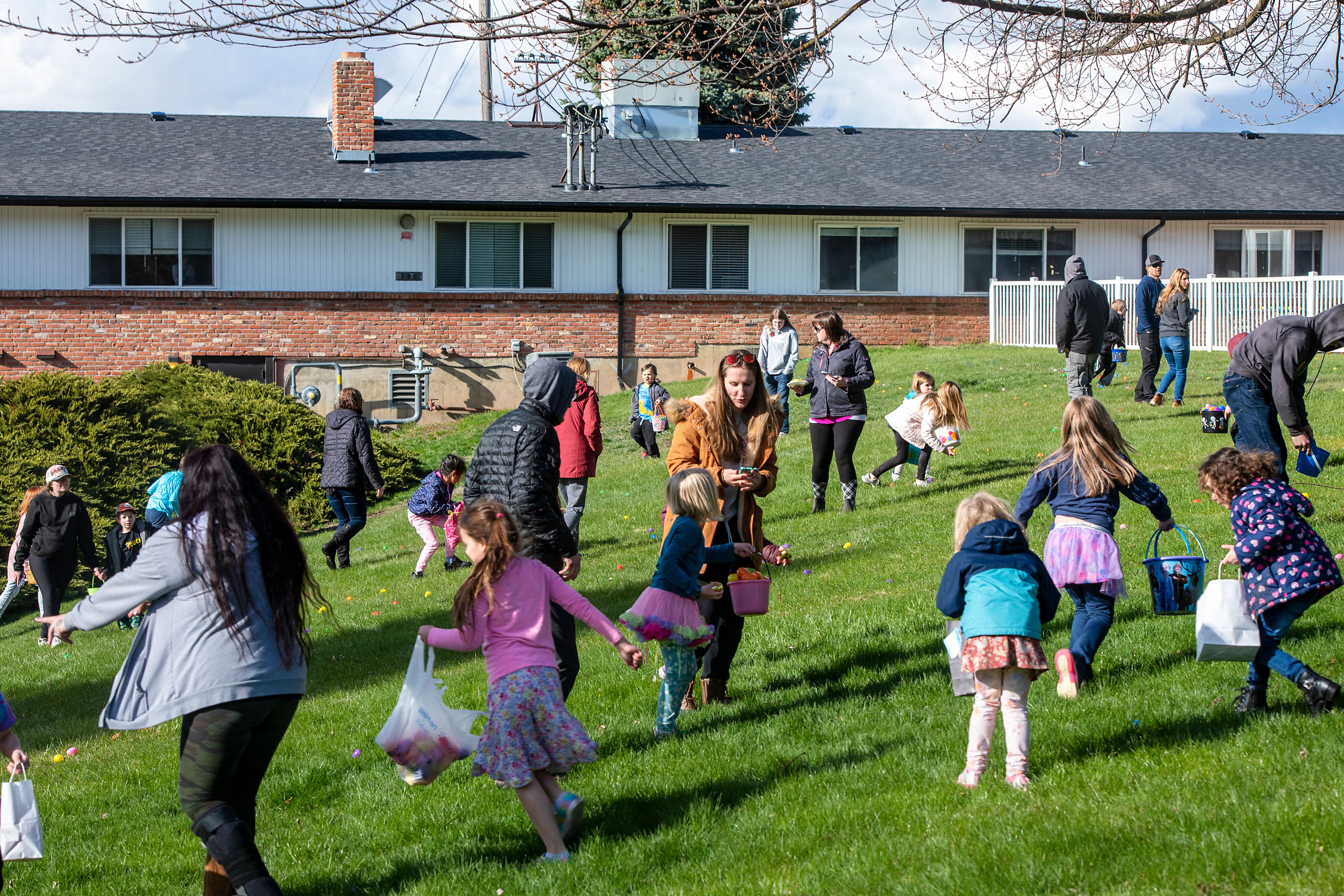 Zach Wilkinson/Daily News Parents assist their children in the annual Easter egg hunt Friday at Aspen Park of Cascadia in Moscow.