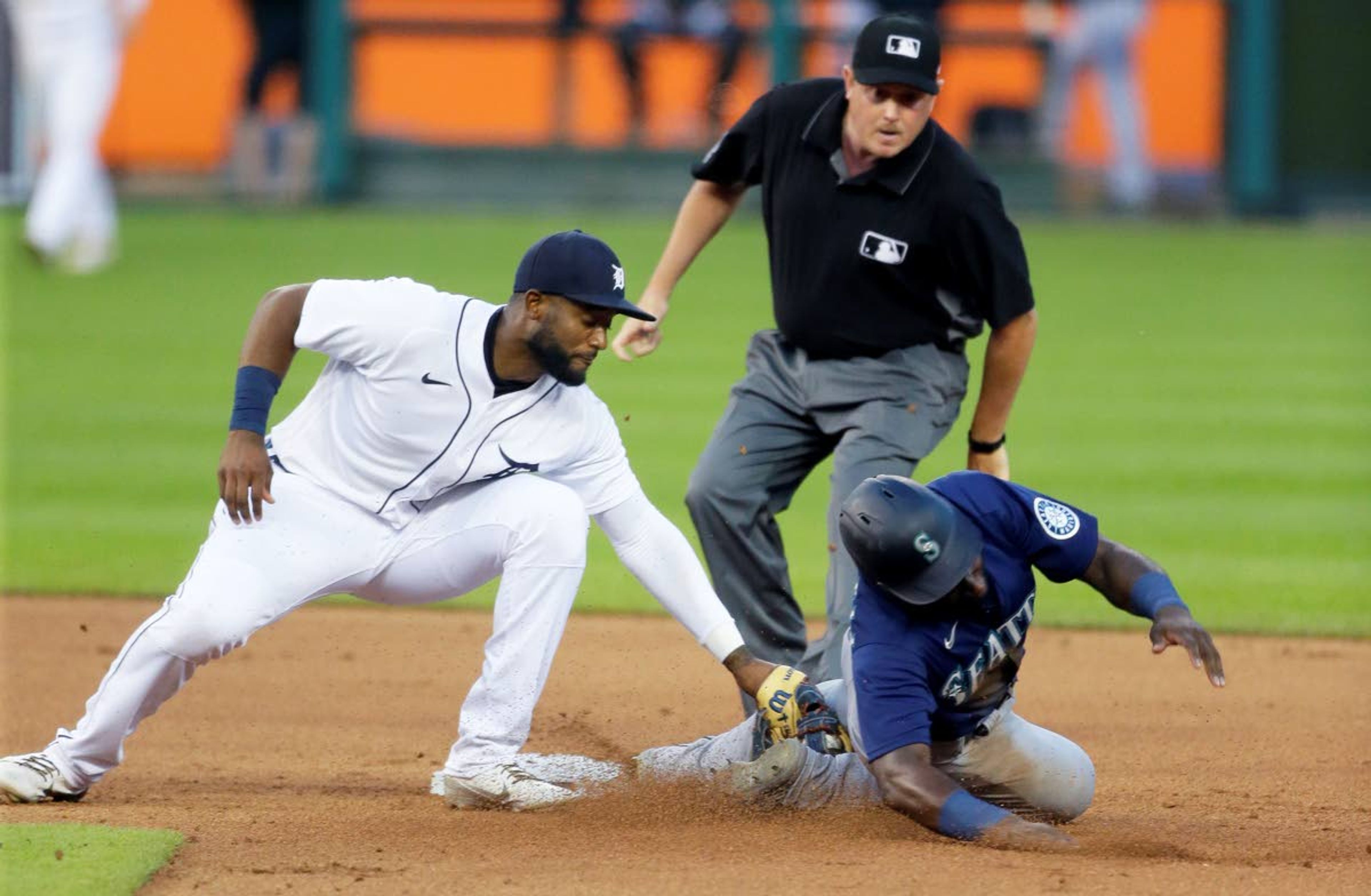 Detroit Tigers shortstop Niko Goodrum, left, tags out Seattle Mariners' Taylor Trammell trying to steal second base during the sixth inning of a baseball game Wednesday, June 9, 2021, in Detroit. (AP Photo/Duane Burleson)