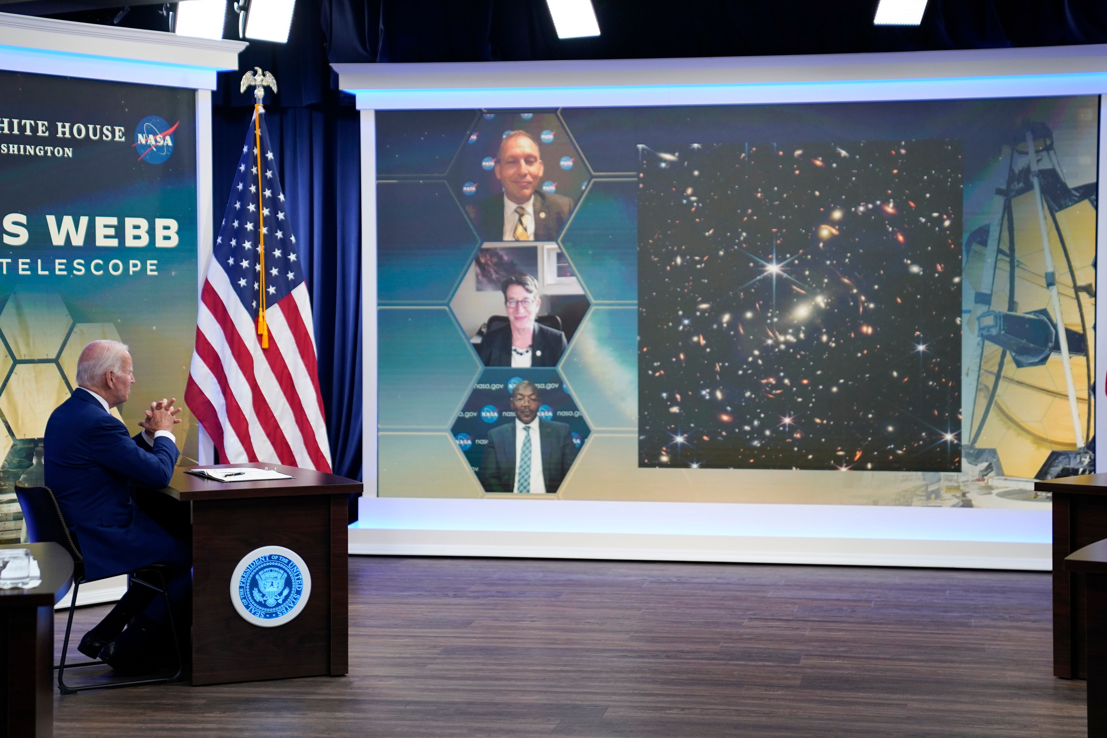 President Joe Biden listens during a briefing from NASA officials about the first images from the Webb Space Telescope, the highest-resolution images of the infrared universe ever captured, in the South Court Auditorium on the White House complex, Monday, July 11, 2022, in Washington. On screen are NASA Associate Administrator for the Science Mission Directorate Thomas Zurbuchen, top, Deputy Director of the Space Telescope Science Institute (STScI) Nancy Levenson, and NASA James Webb Space Telescope Program Director Greg Robinson, bottom. (AP Photo/Evan Vucci)