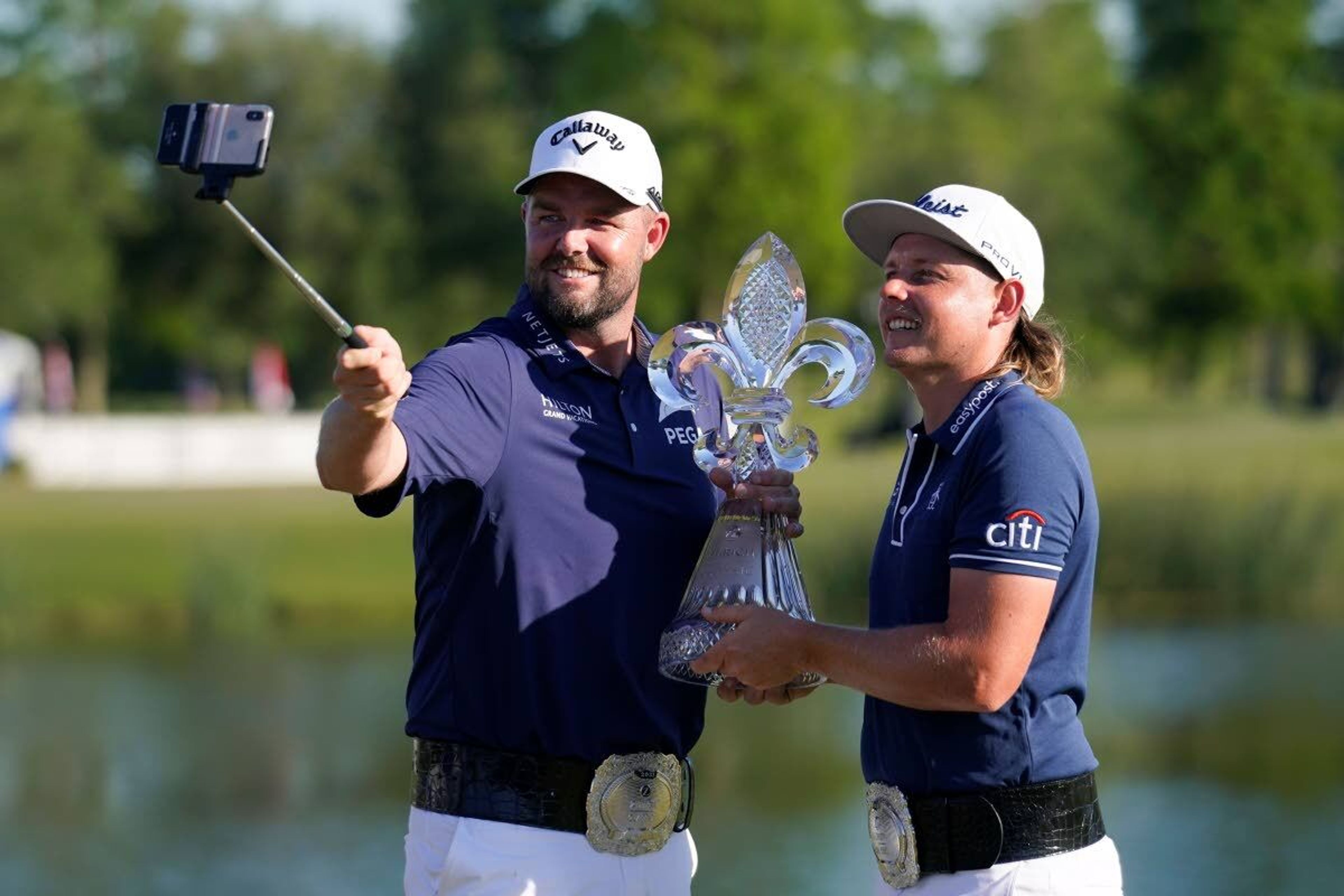 Marc Leishman, of Australia, left, and teammate Cameron Smith, of Australia, hold the trophy after winning the PGA Zurich Classic golf tournament at TPC Louisiana in Avondale, La., Sunday, April 25, 2021.