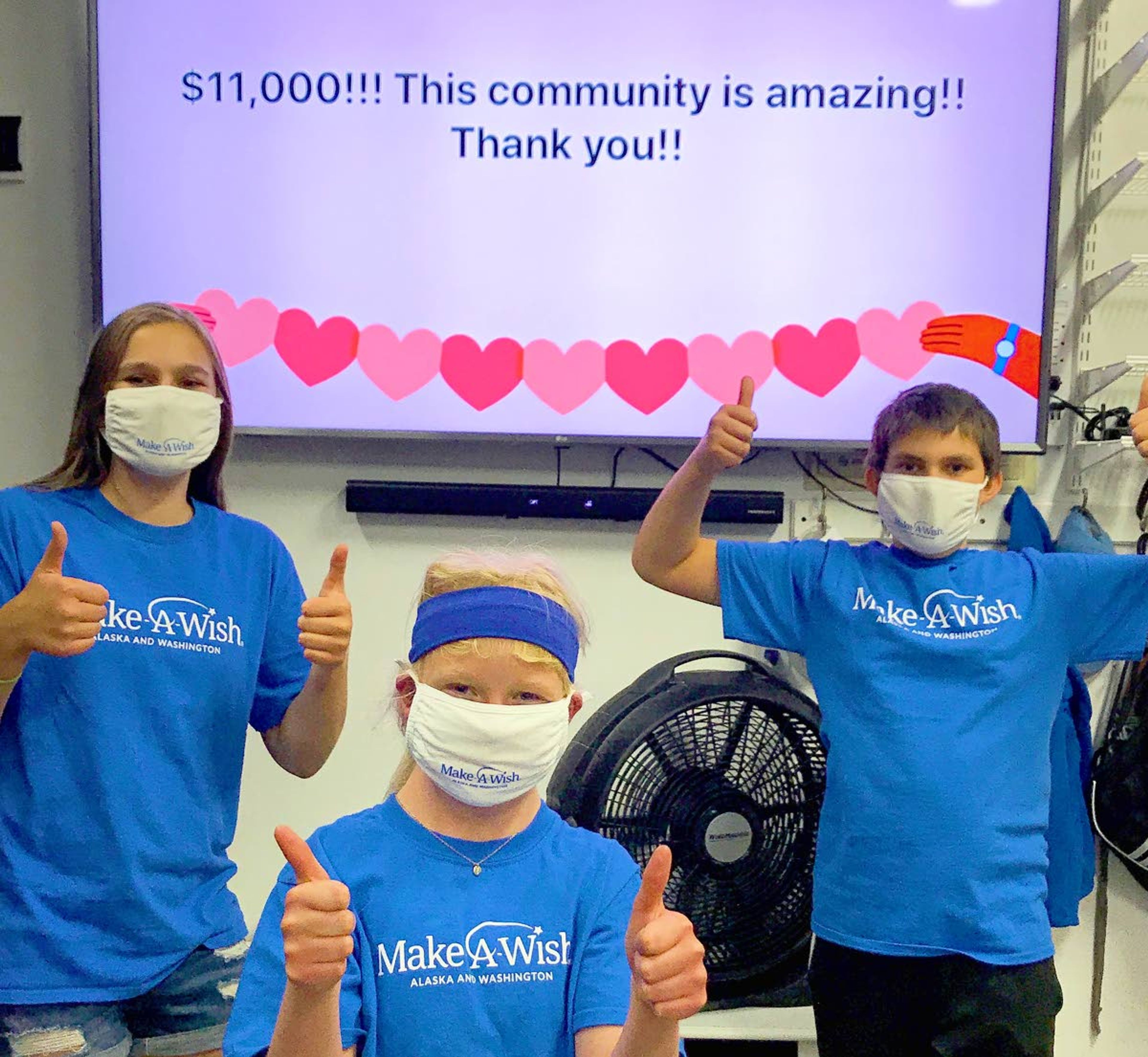 Marissa Carper, left to right, Shay Connell and Jack Carper give a masked thumbs up to the community for their support of the fundraiser.