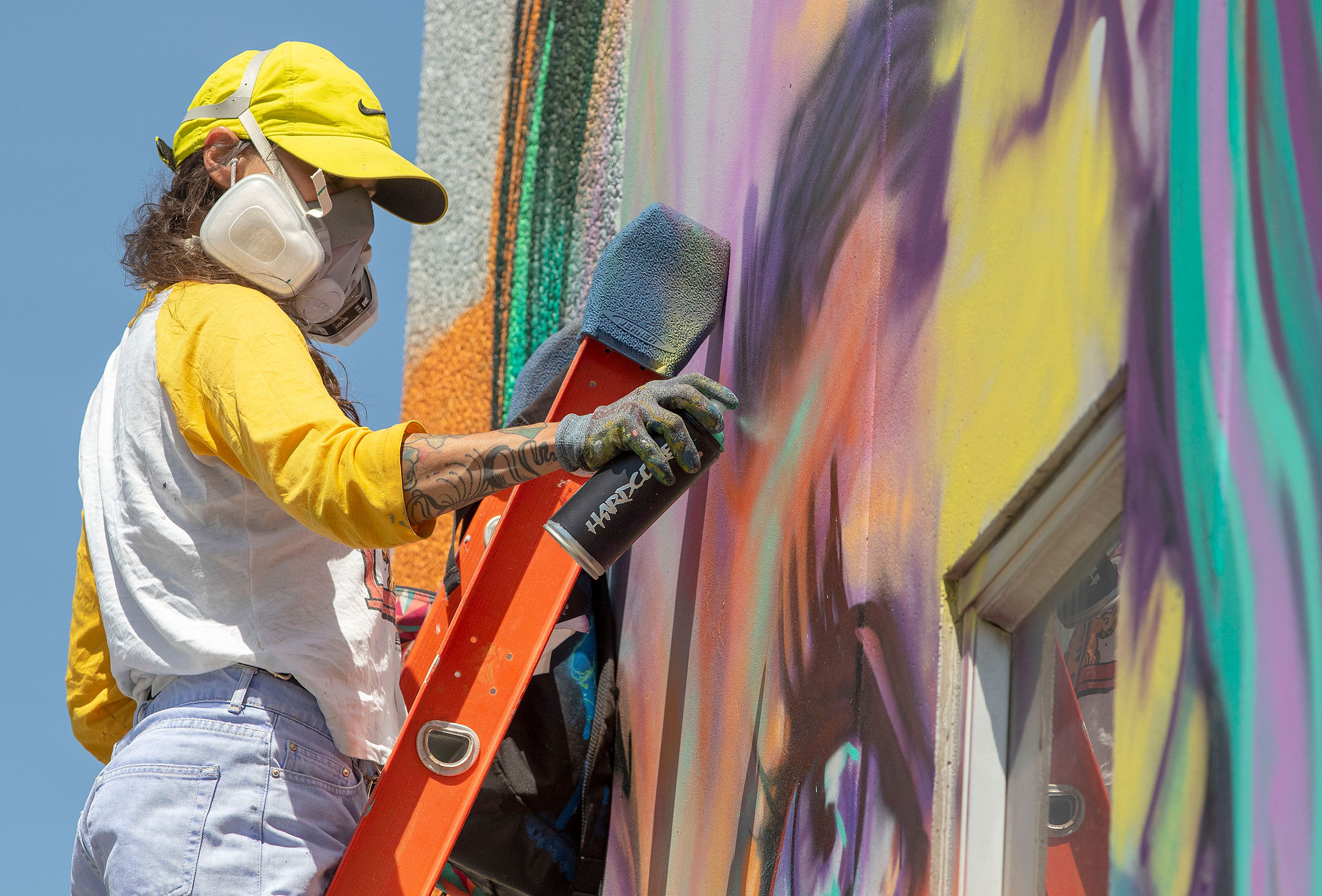 Camille Cote, who creates art under the name FABS, works on a mural on the Moscow Water Filter Plant on Monday on North Jackson Street. The mural depicts an educational cross-section of the local aquifer, as well as some of the people and plants that depend on it. The mural will be finished in time for Moscow Art Walk, which starts June 21.