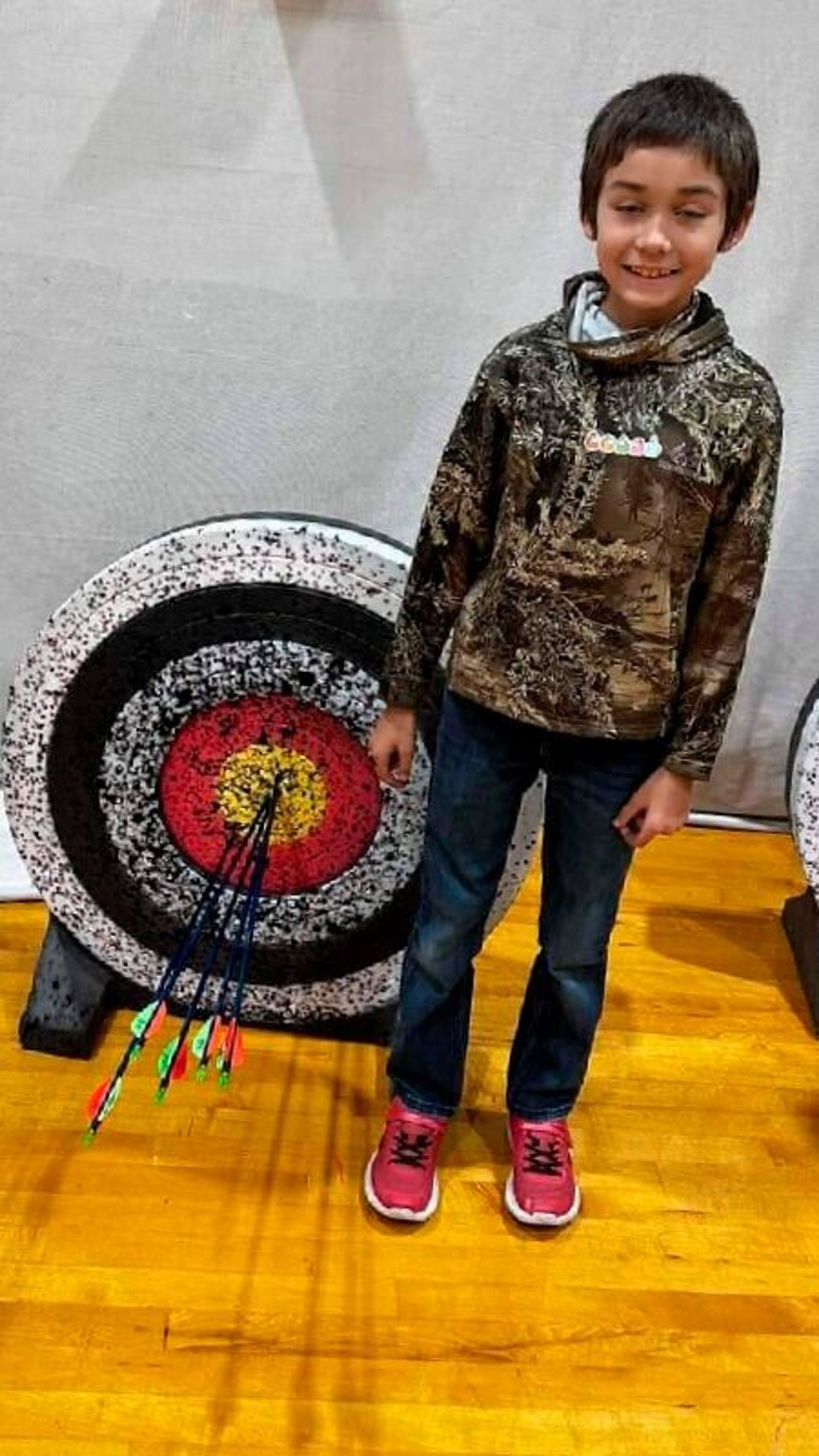 Hunter Owens stands in front of a target where he hit a perfect round of bullseyes.