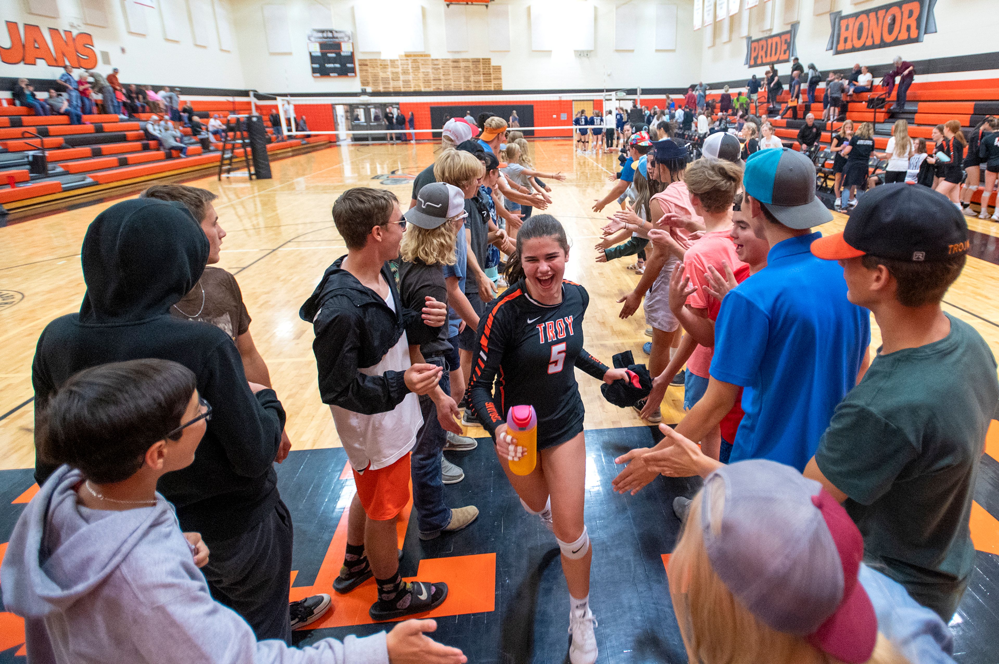 Troy’s Bethany Phillis (5) runs through a line of Troy students in celebration after defeating Logos in a Whitepine League matchup at Troy High School on Tuesday.