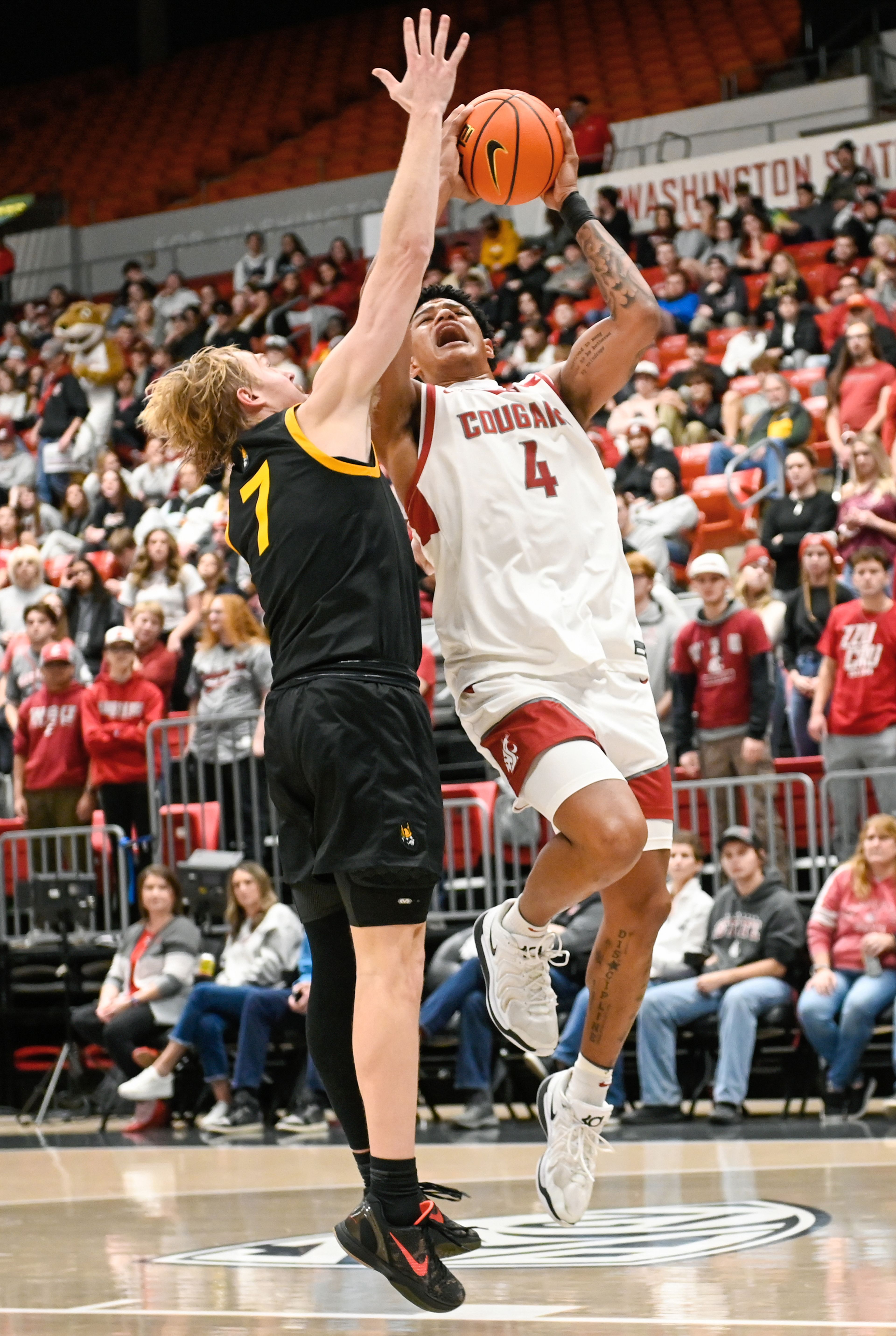 Idaho guard Jack Payne blocks Washington State forward LeJuan Watts from a shot under the net Monday during the Battle of the Palouse game at Beasley Coliseum in Pullman.