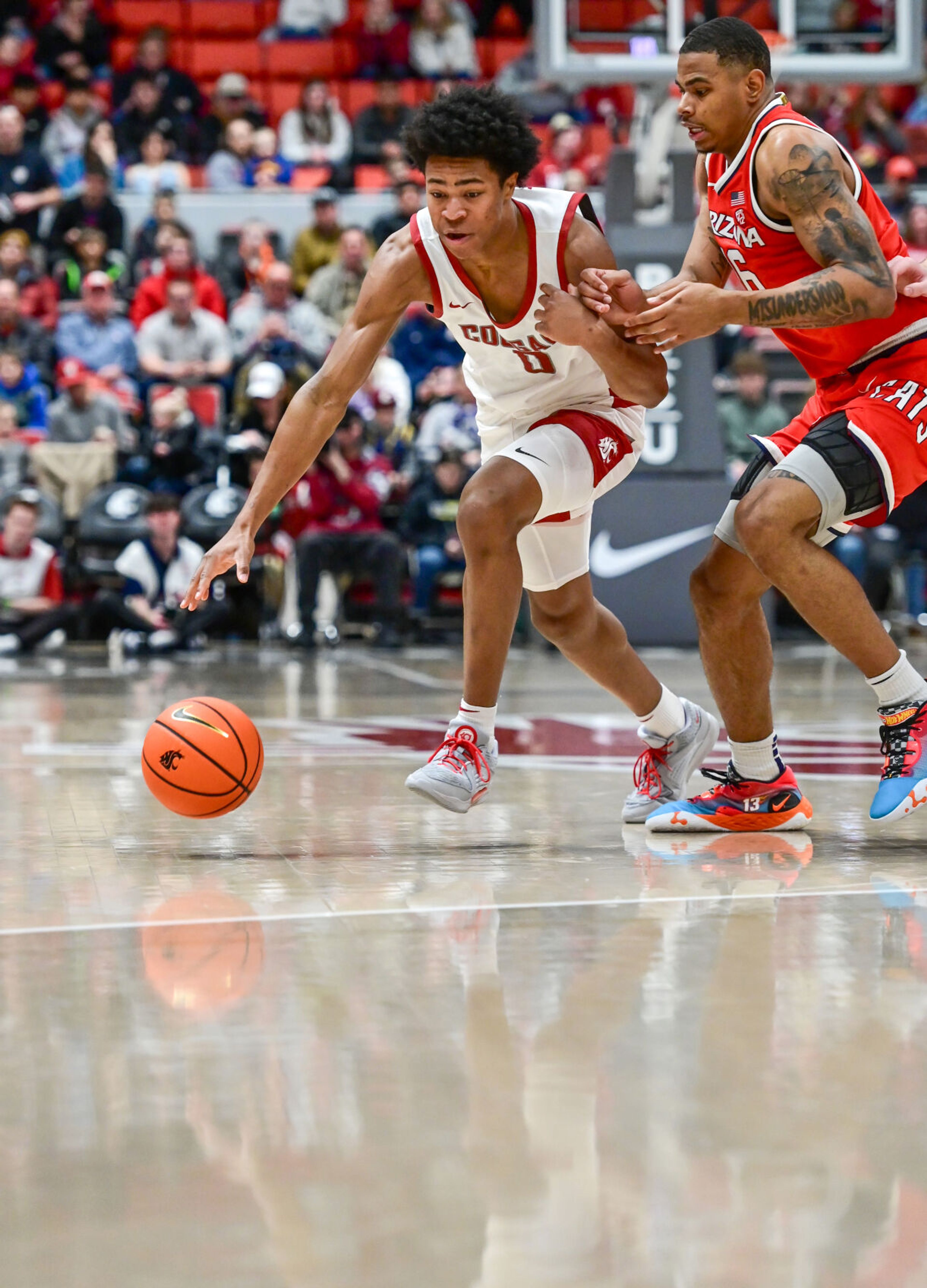 Washington State forward Jaylen Wells (0) dribbles the ball past Arizona forward Keshad Johnson (16) during a game Jan. 13 in Pullman.