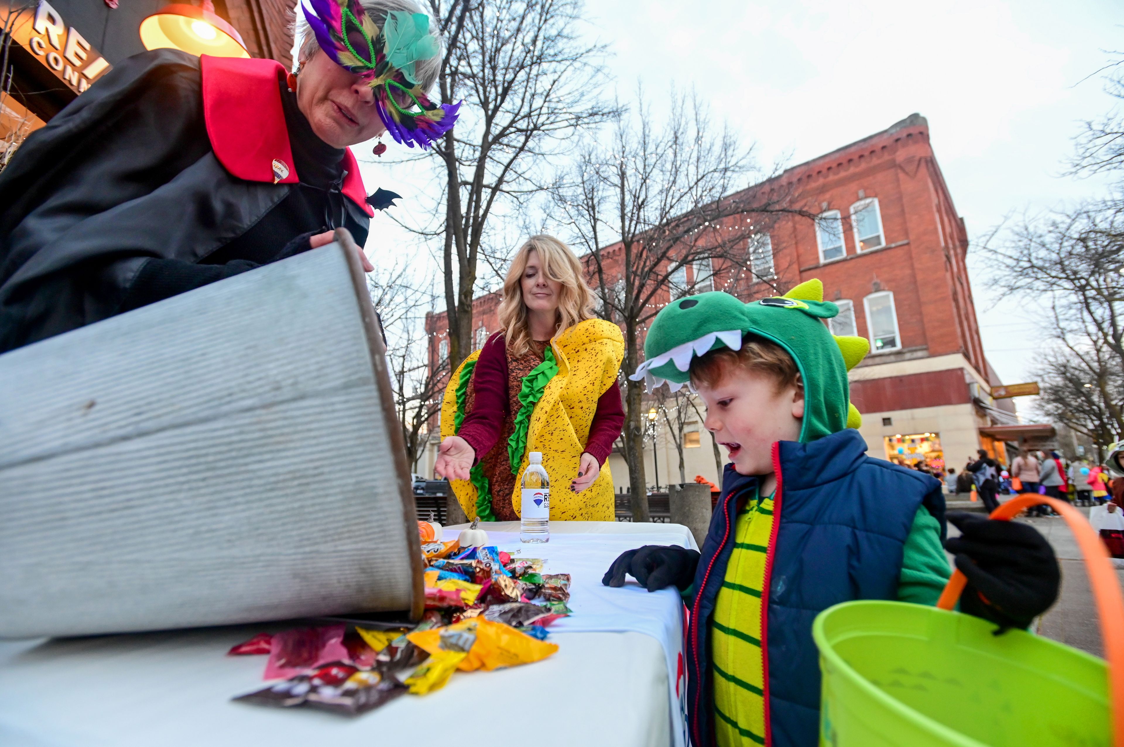 Matthew Drenker, 5, right, looks down at the candy options before picking M&Ms from the pile at the RE/MAX Connections table set up for Moscow’s Downtown Trick-or-Treat on Tuesday.