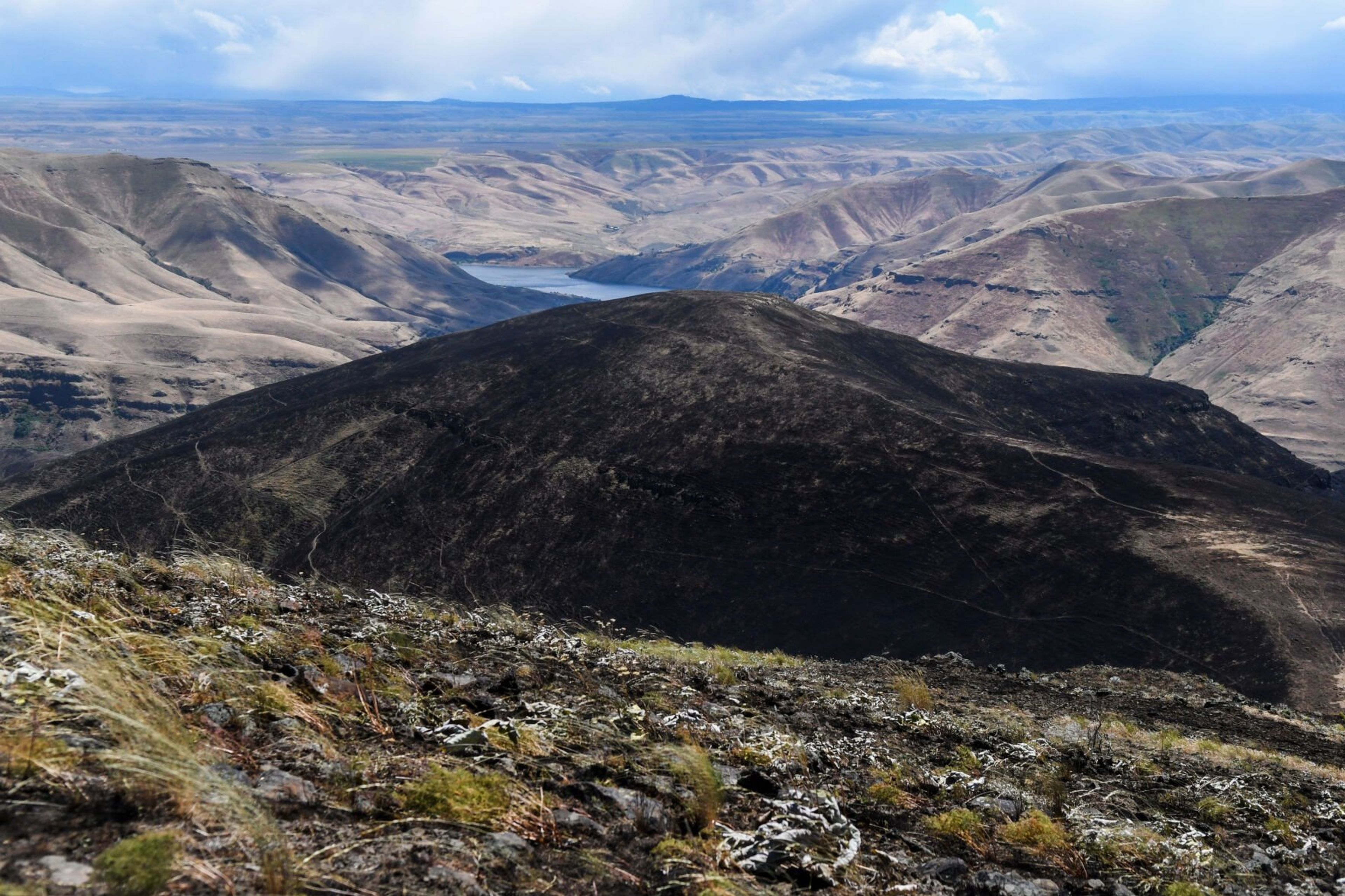 A view on Saturday from the east of the Snake River shows charred land leading to a darkened summit after roughly 300-acres burned in a wildfire between Nisqually John Landing and Steptoe Canyon.