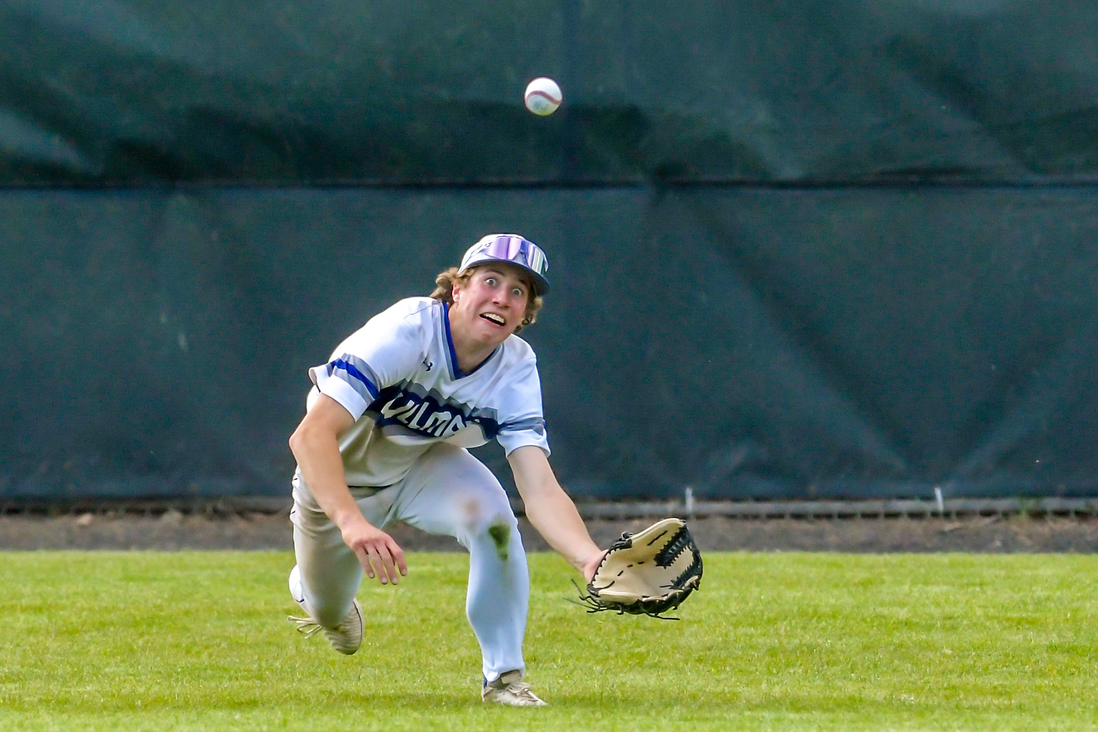 Pullman center fielder Joey Hecker goes after a ball but misses the catch against Clarkston during a semifinal game of the district tournament Thursday in Pullman.