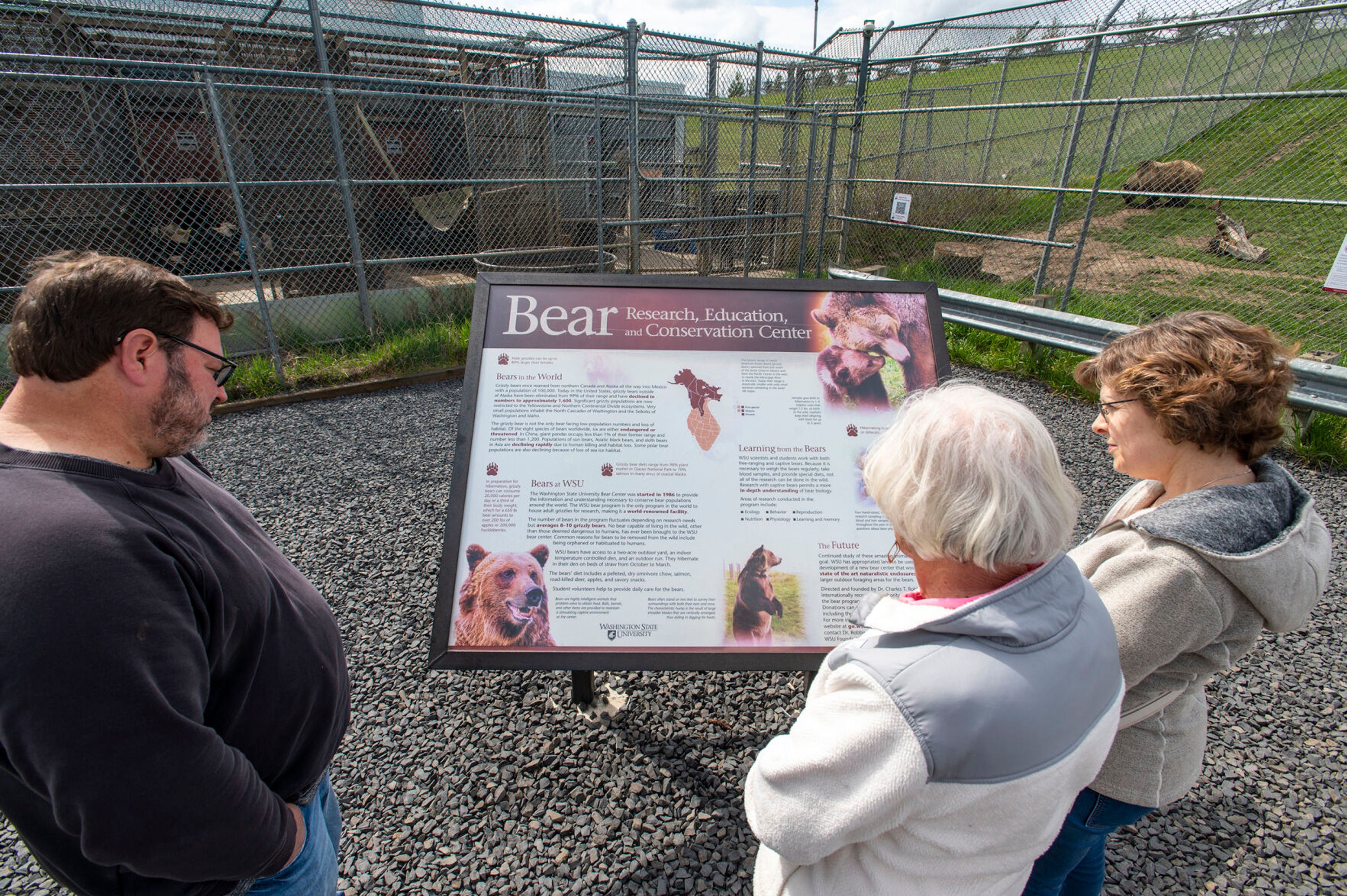 Terry Hotchkiss, from left, Thelma Razor and Mary Hotchkiss examine an informational sign at Washington State University’s Bear Center in Pullman.