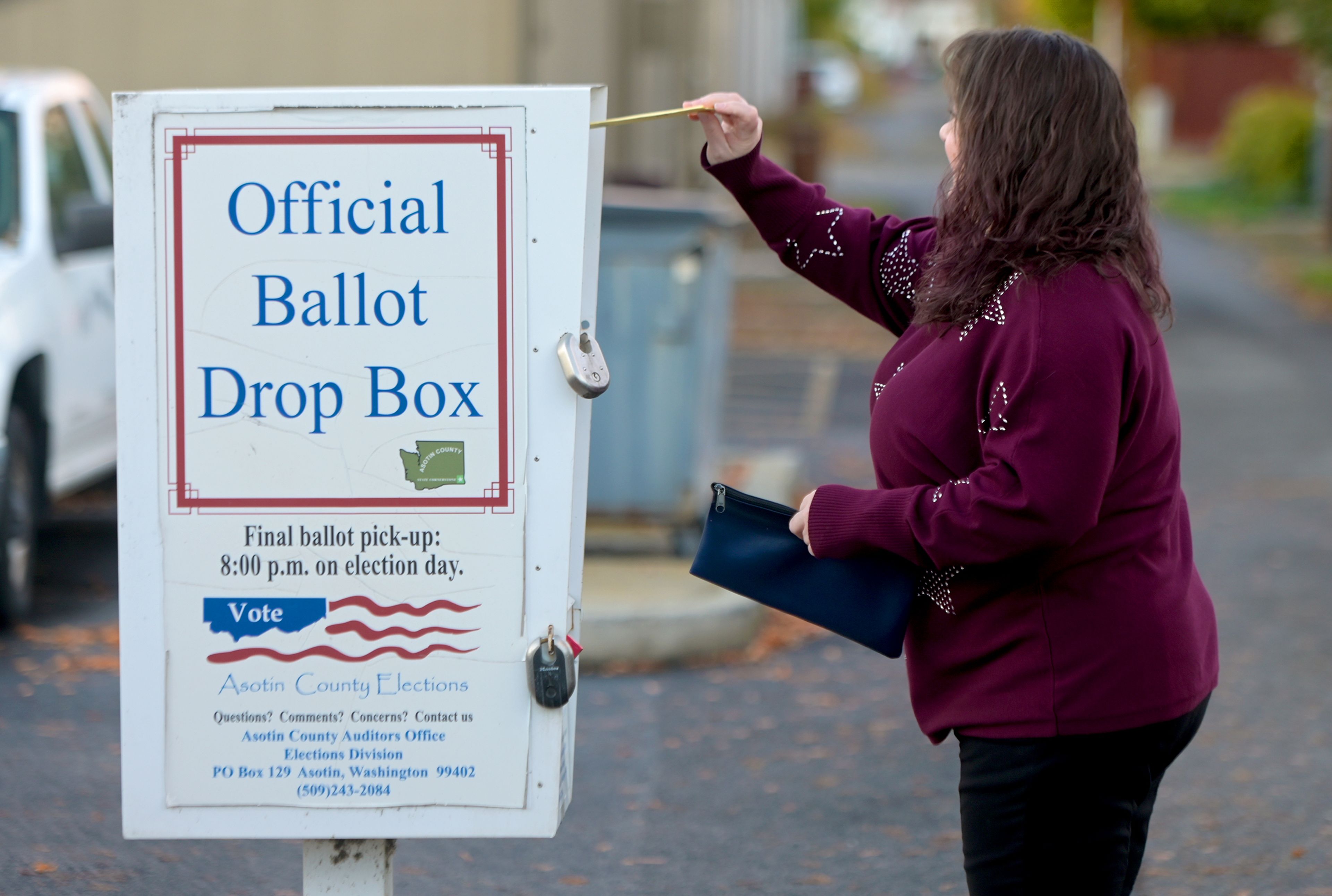 A ballot is dropped off at a ballot box Monday at Clarkston City Hall in Clarkston.