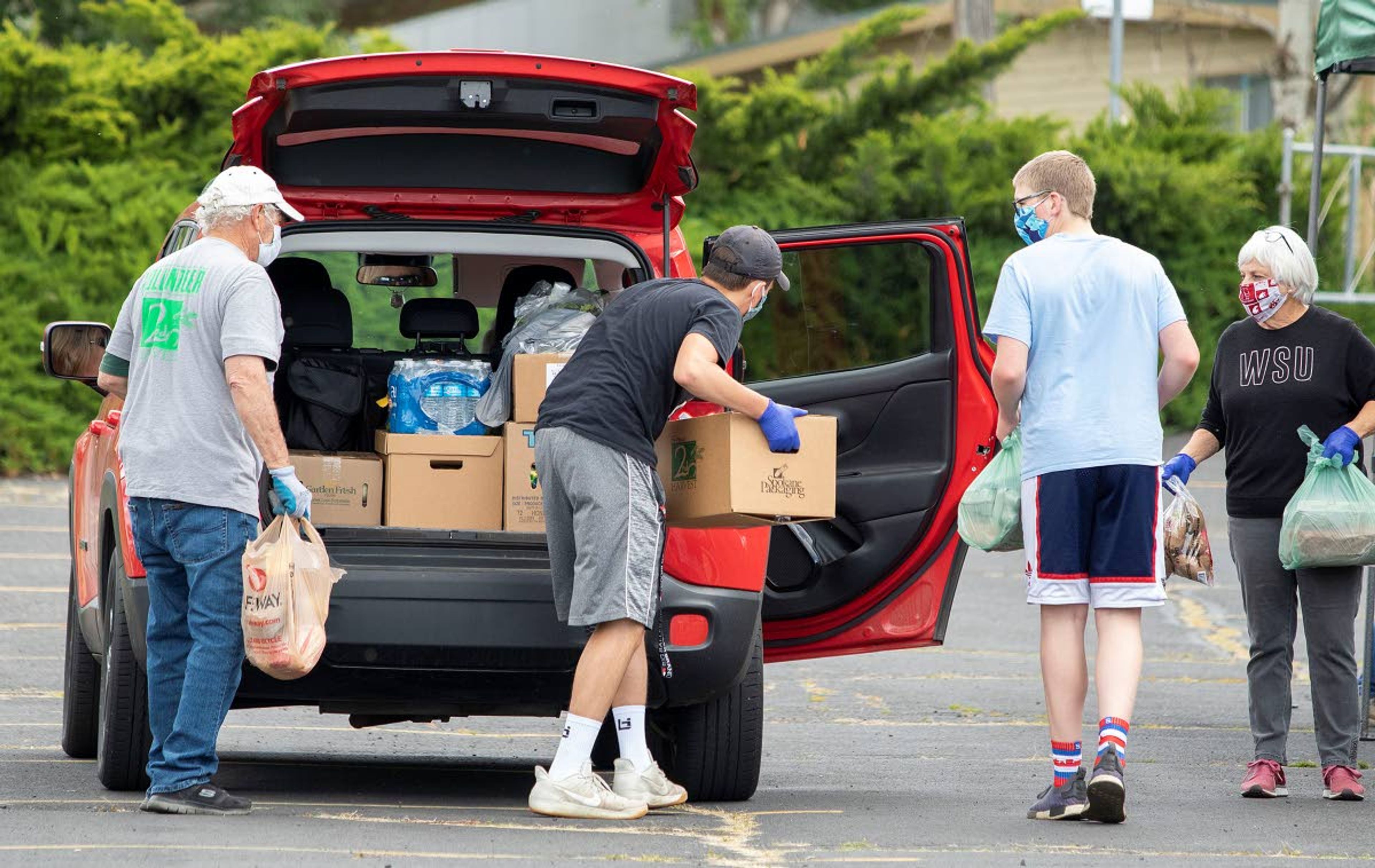 Volunteers load food into a resident's car during a free food distribution on Wednesday at Trinity Lutheran Church in Pullman. The event was organized by the church in cooperation with 2nd Harvest from Spokane.