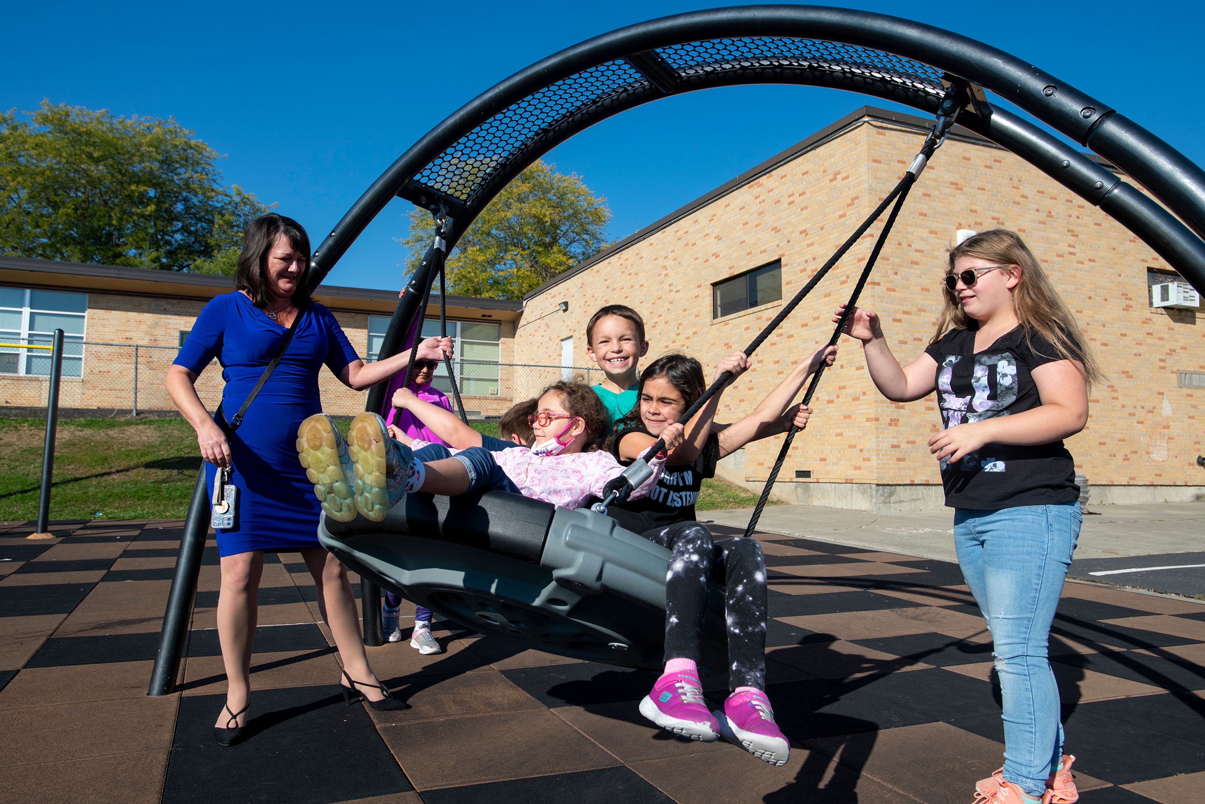 Principal Kendra McMillan helps swing students on Lena Whitmore Elementary School’s Americans with Disabilities Act-approved play structure in Moscow.