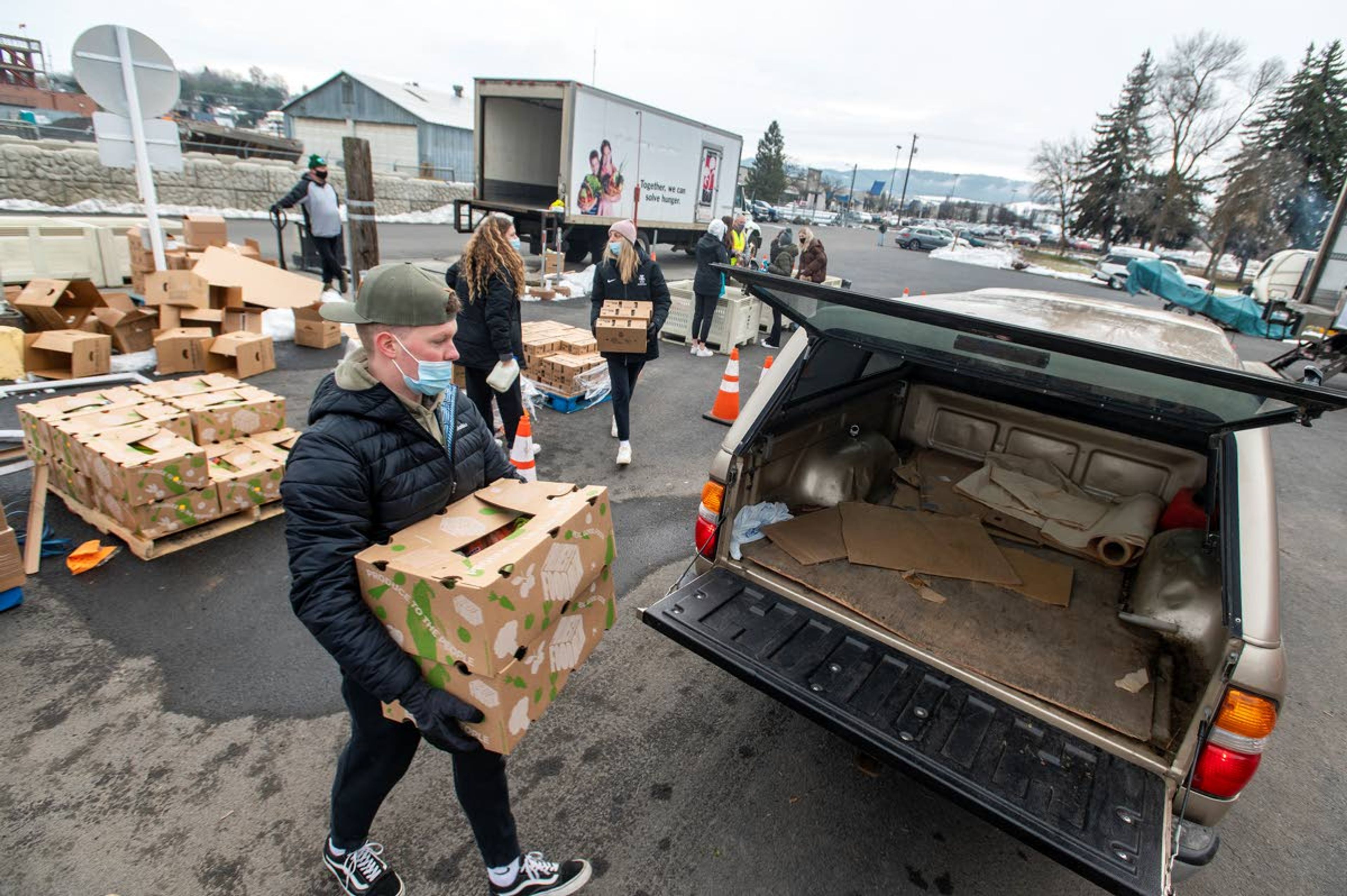 University of Idaho students load boxes of food into a line of vehicles Monday as they volunteer for The Idaho Foodbank at the Latah County Fairgrounds in Moscow.