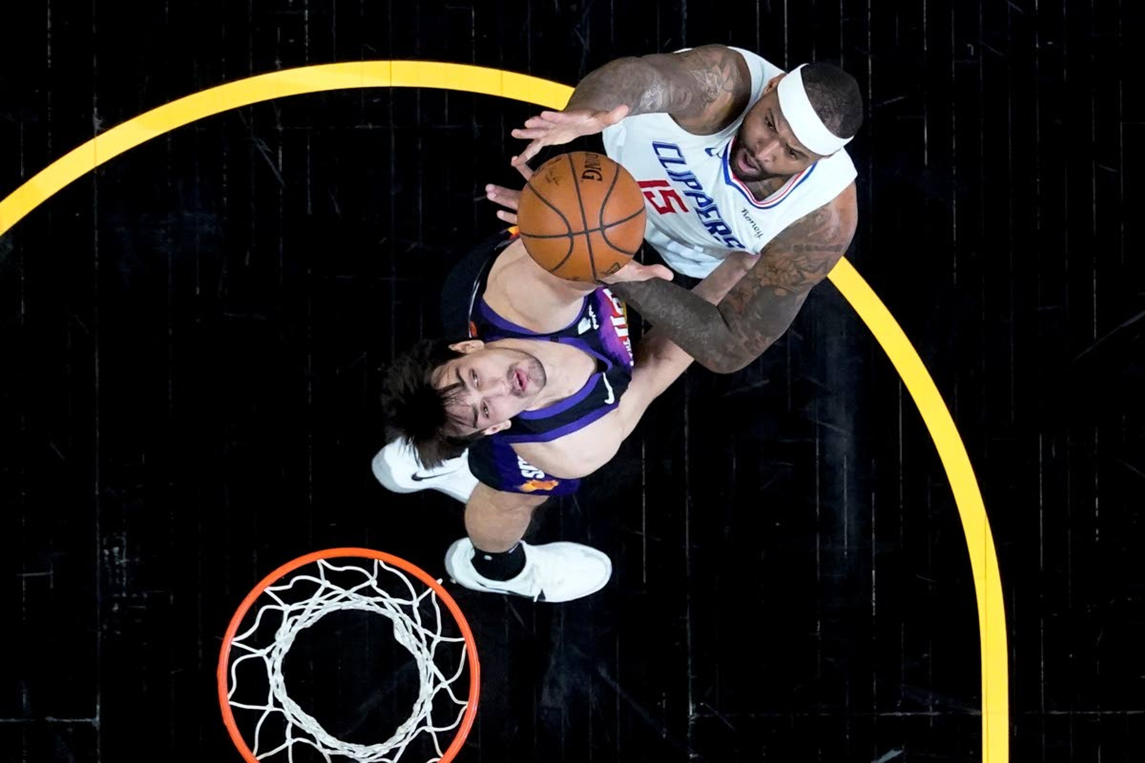 Los Angeles Clippers center DeMarcus Cousins (15) shoots over Phoenix Suns forward Dario Saric during the first half of game 5 of the NBA basketball Western Conference Finals, Monday, June 28, 2021, in Phoenix. (AP Photo/Matt York)