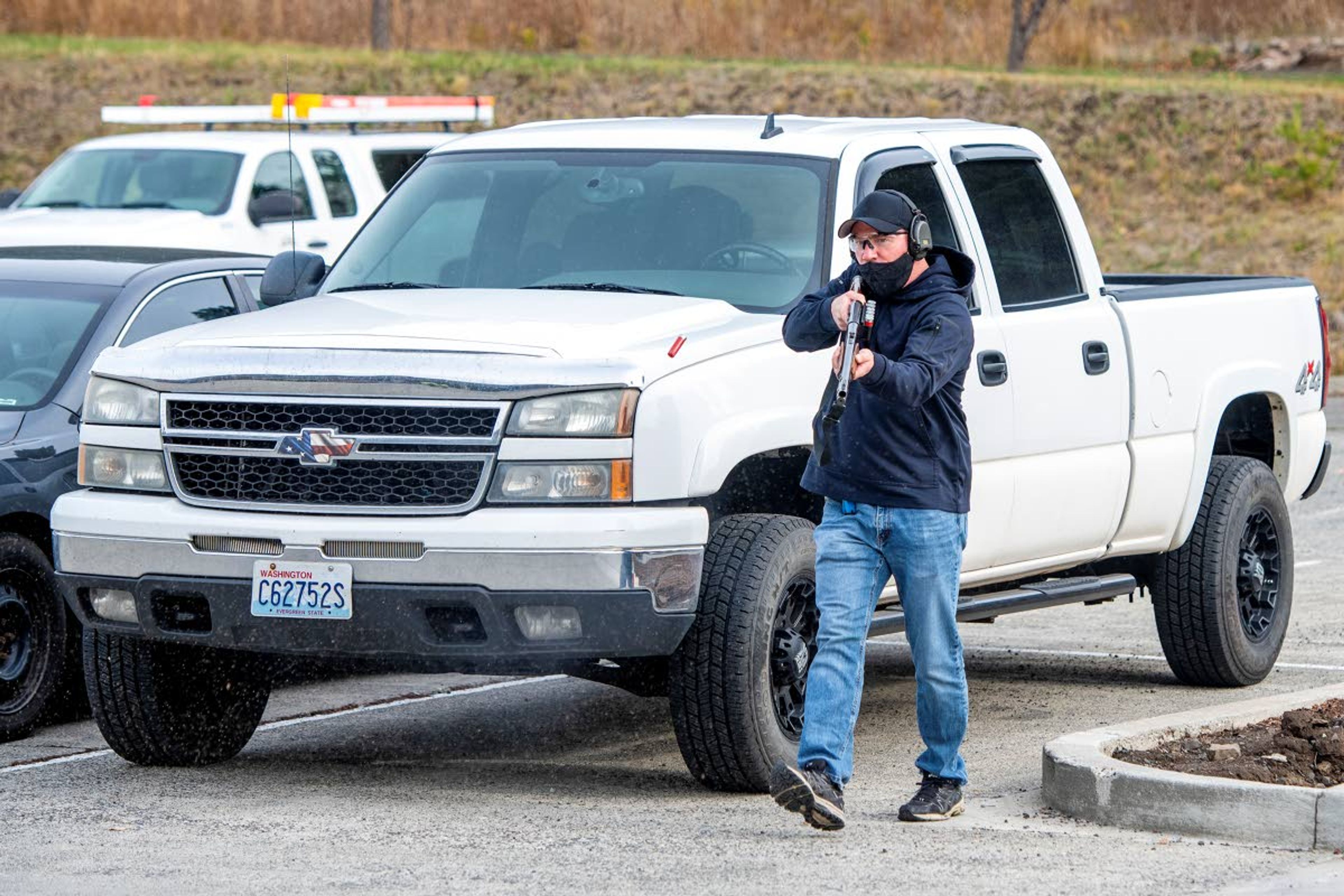 Officer Ruben Harris of the Pullman Police Department portrays an attacker as he fires a blank round from his shotgun while walking toward Pullman City Hall during active shooter training on Wednesday afternoon.