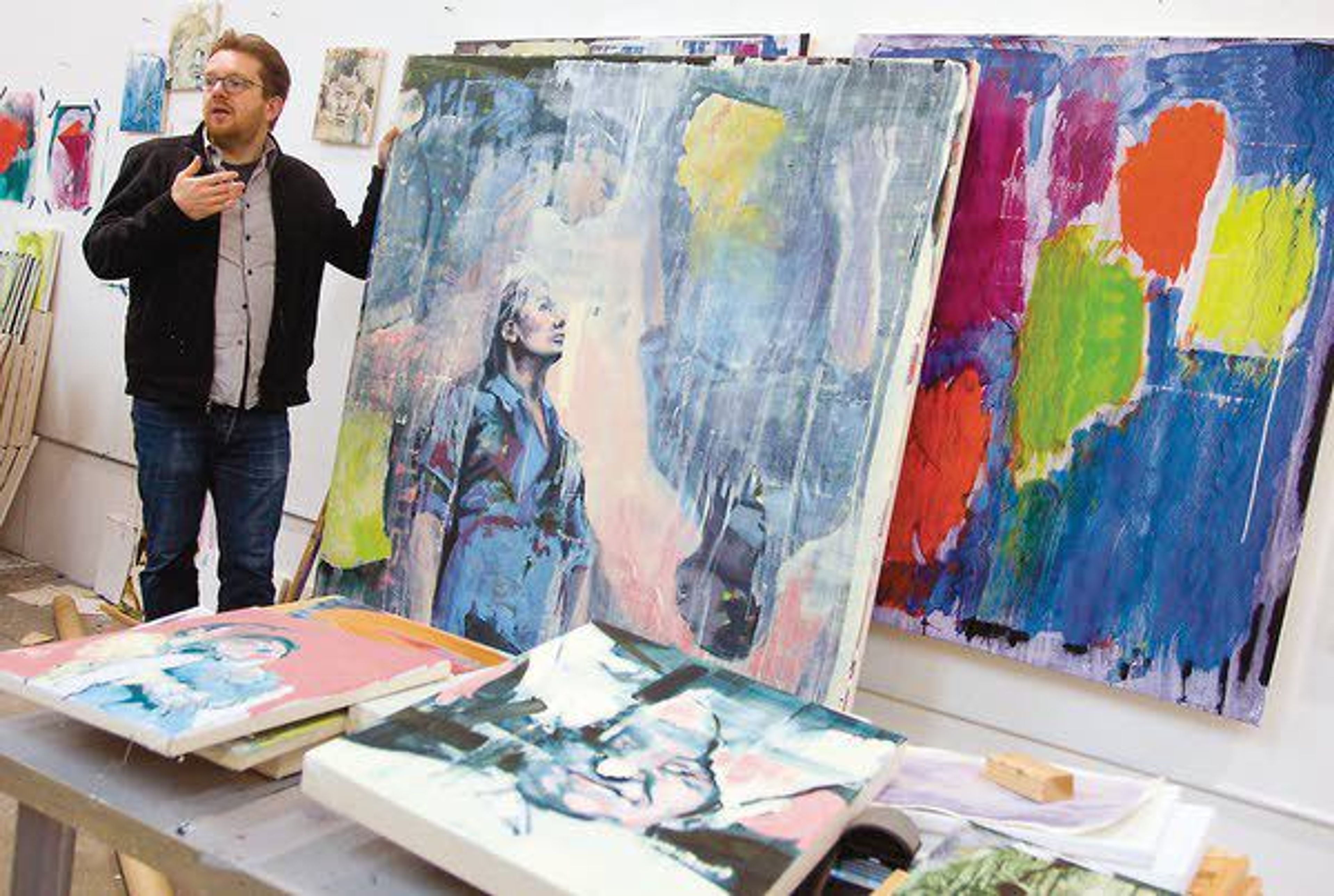 Bartosz Beda talks about his oil paintings Friday at his studio in Moscow.