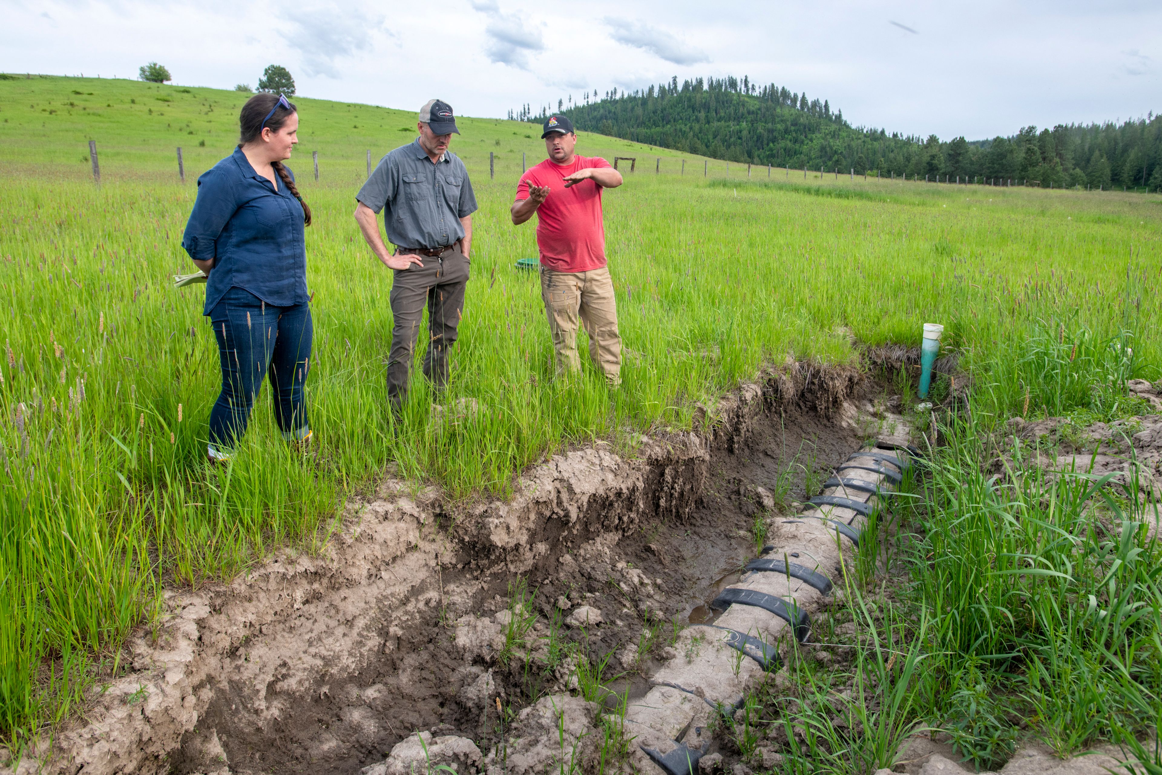 DEQ Compliance Officer Jen Doughty, from left, Hoodoo Water and Sewer District board member, from left, Kenny Merten and operator Leonard Johnson discuss the overflow of water coming up from one of the ADS chambers in Harvard’s sewage system on Wednesday.