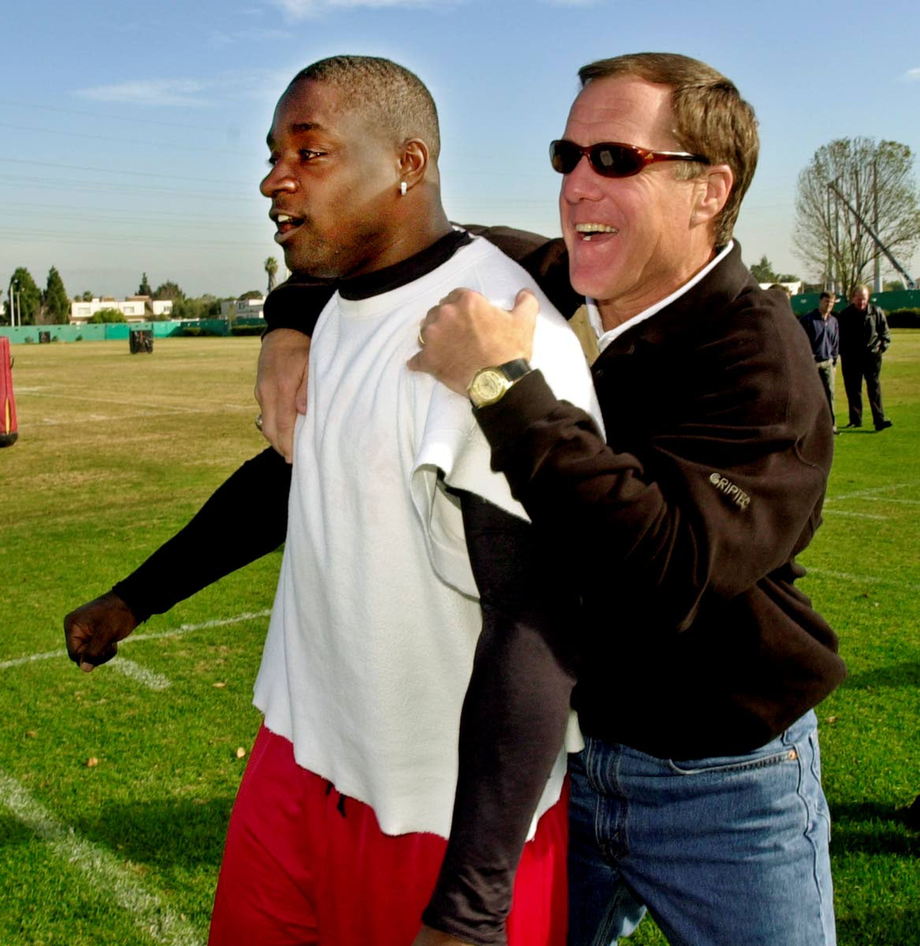 FILE - In this Thursday, Jan. 10, 2002, file photo, San Francisco 49ers running back Garrison Hearst, left, is congratulated by 49ers general manager Terry Donahue during practice at the 49ers training camp in Santa Clara, Calif., as Hearst won The Associated Press NFL Comeback Player of the Year Award. Donahue, the winningest coach in Pac-12 Conference and UCLA football history who later served as general manager of the NFL’s San Francisco 49ers, died Sunday, July 4, 2021. He was 77. (AP Photo/Paul Sakuma, File)