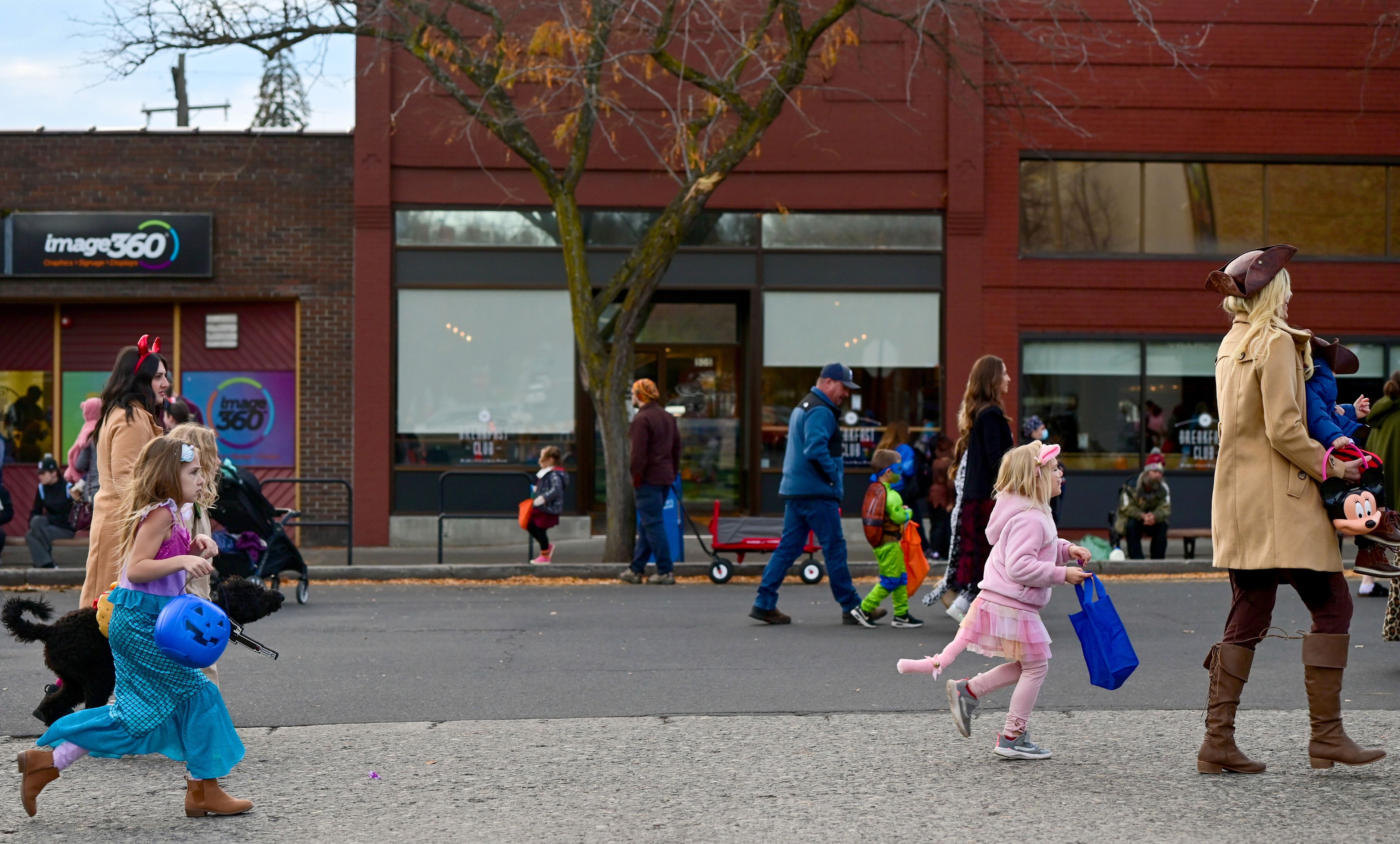 Kids run down the street in anticipation of the next candy stop along Main Street for Moscow’s Downtown Trick-or-Treat on Tuesday.