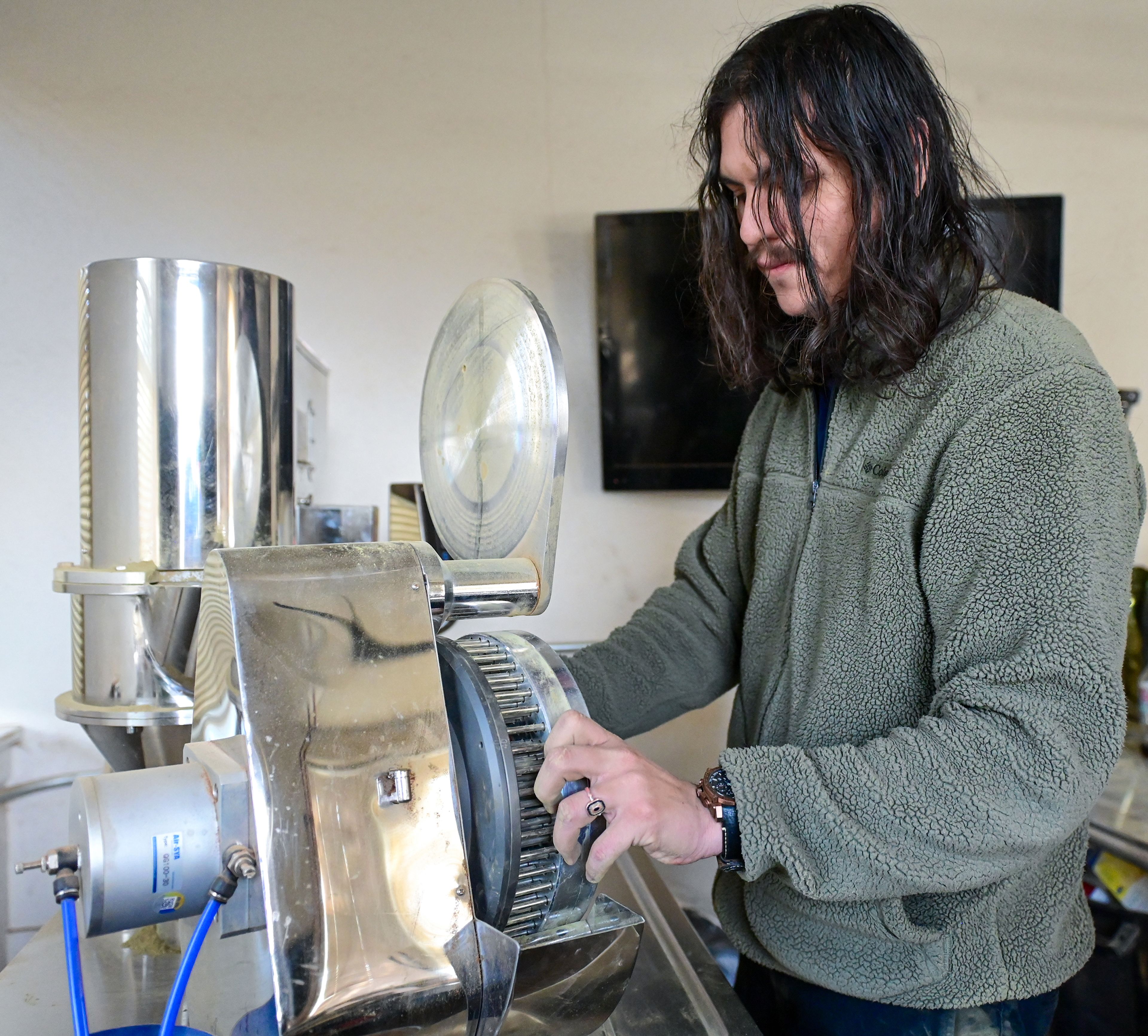 Kratom Kings owner Guillermo Rojo Martinez operates machinery to fill capsules with kratom powder Friday at the shop in Moscow.