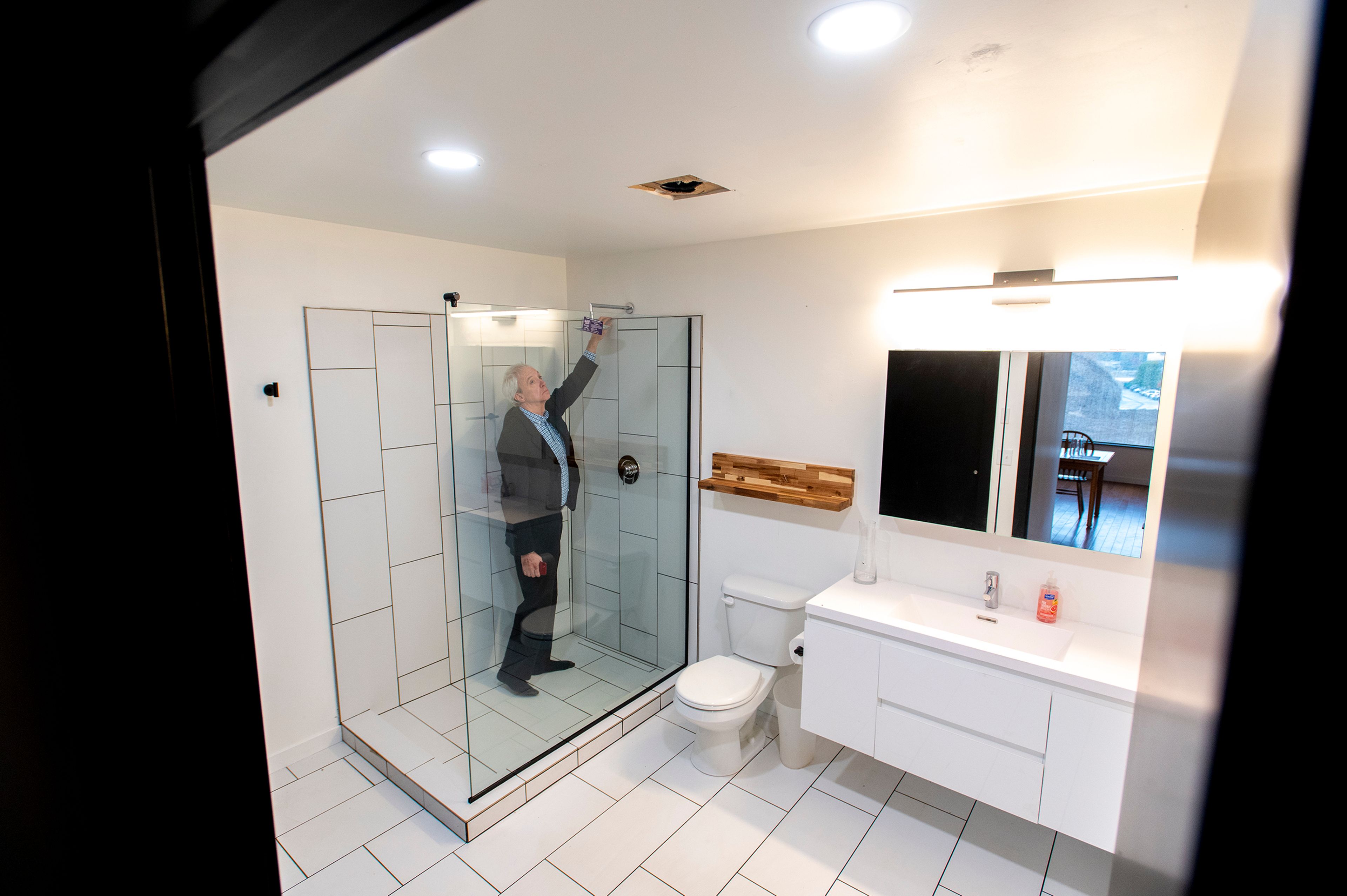 Stan Palmer, a University of Idaho College of Art and Architecture advisory council member, inspects the bathroom of a newly built home by members of Moscow Affordable Housing Trust and the University of Idaho in Moscow on Friday.