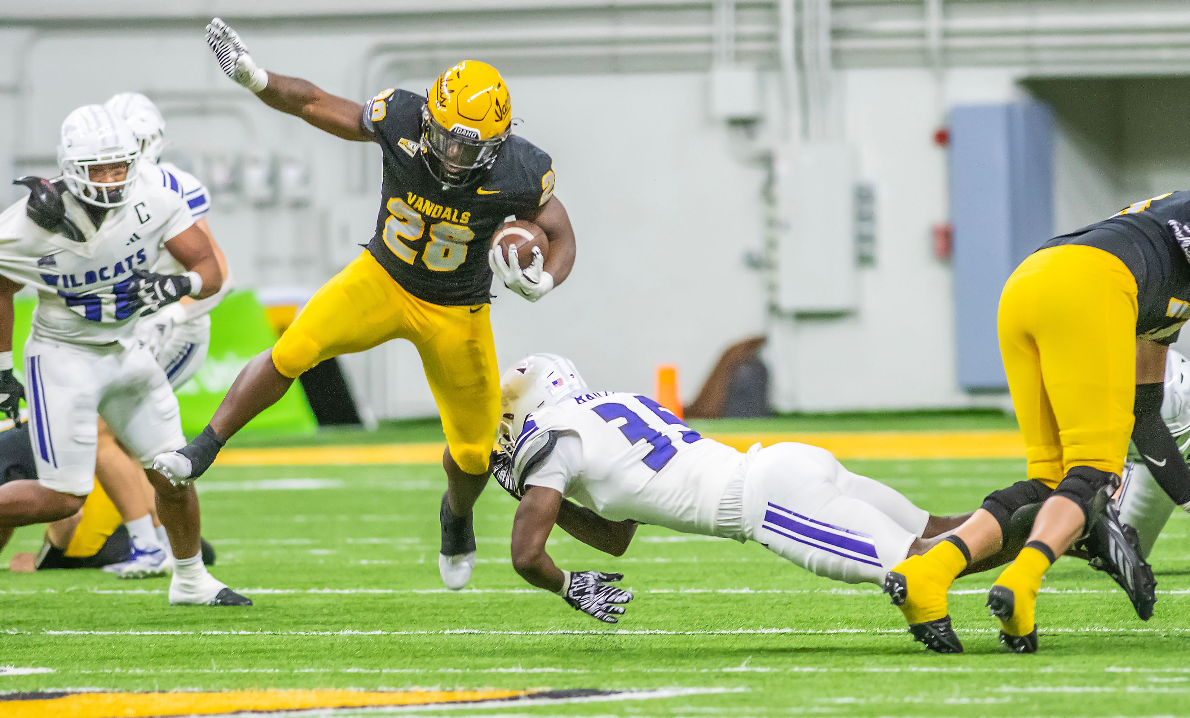 Idaho running back Nate Thomas avoids a hit from Weber State defensive end Kemari Munier-Bailey during a quarter of a Big Sky conference game Saturday at the P1FCU Kibbie Dome in Moscow.