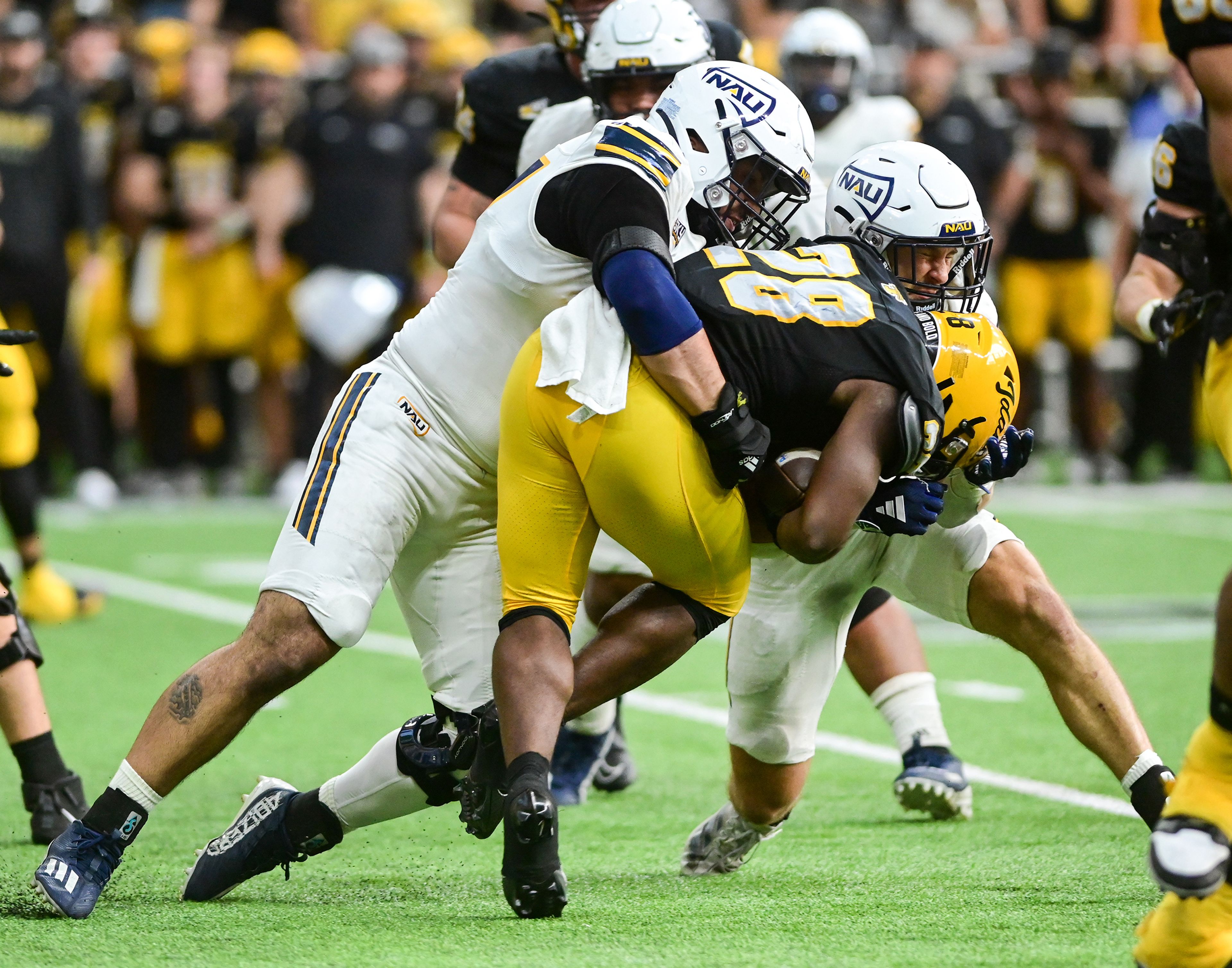 Idaho running back Nate Thomas is tackled by Northern Arizona defenders Saturday at the P1FCU Kibbie Dome in Moscow.,