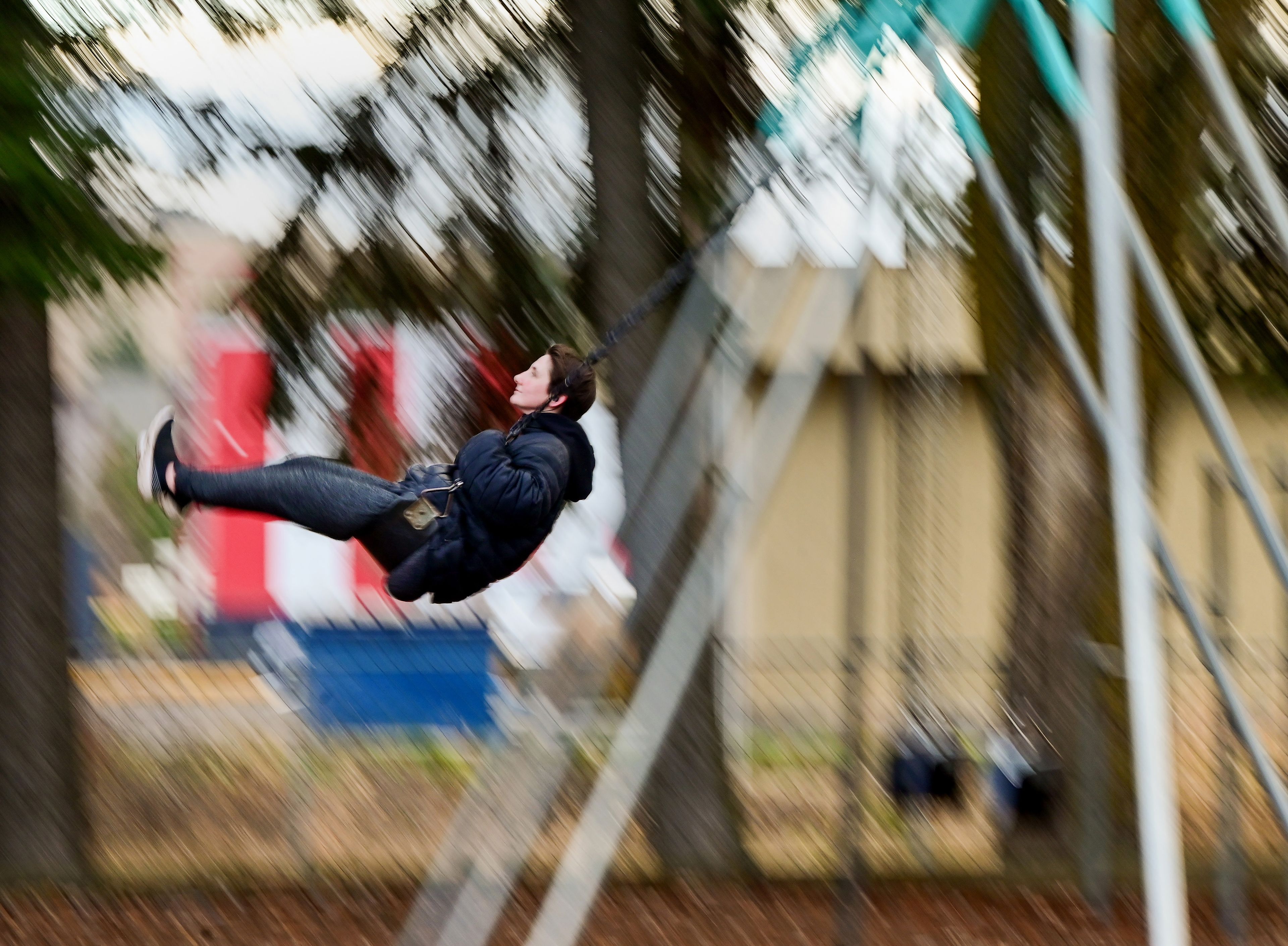 Priscilla Kirkland listens to music while swinging on the swing set at Lions Park in Moscow on Tuesday.