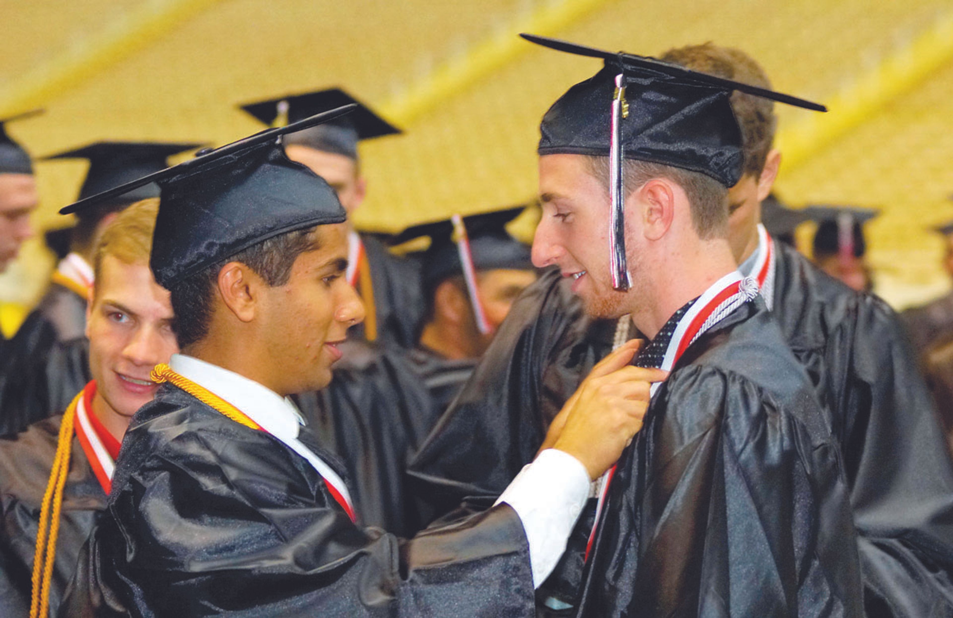 Neeraj Vtgikar, left, adjusts Josh Cargatelli's honor cord and ribbon before Moscow High School's graduation ceremony in the Kibbie Dome Friday evening.