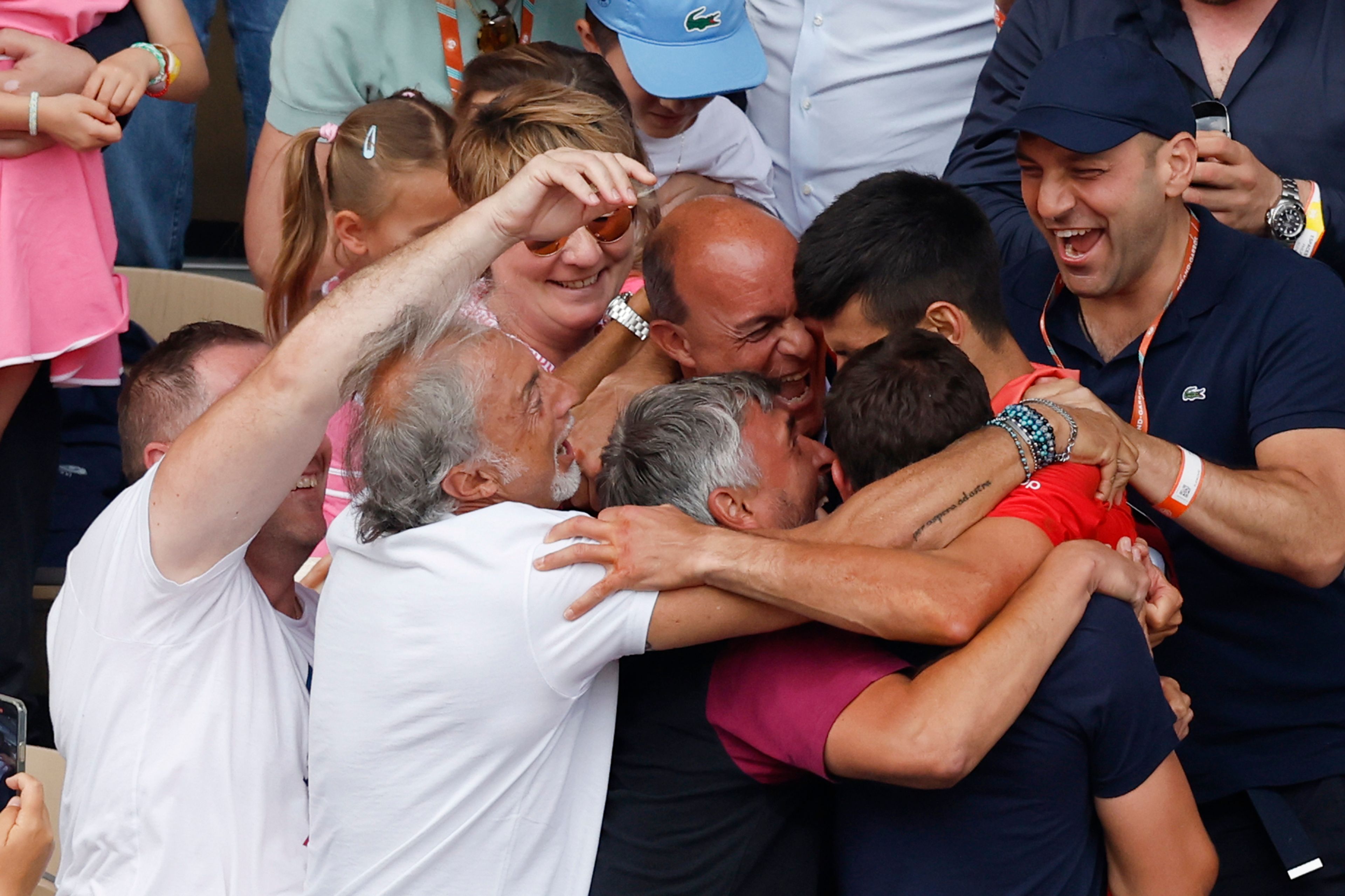 Serbia's Novak Djokovic hugs his family and members of his team as he celebrates winning the men's singles final match of the French Open tennis tournament against Norway's Casper Ruud in three sets, 7-6, (7-1), 6-3, 7-5, at the Roland Garros stadium in Paris, Sunday, June 11, 2023. (AP Photo/Jean-Francois Badias)