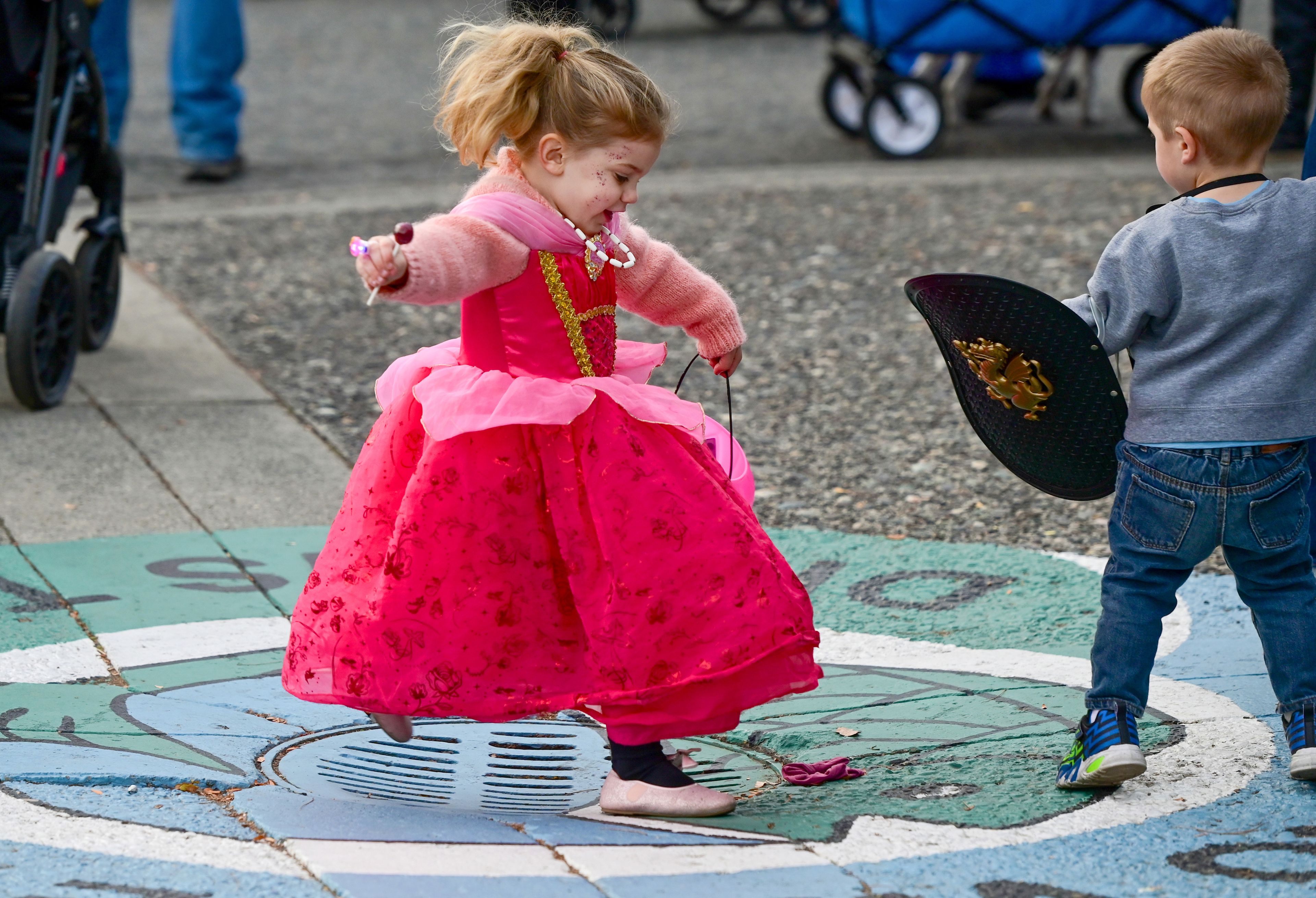 June Engerbretson, left, jumps over a drain holding a lollipop during Moscow’s Downtown Trick-or-Treat on Tuesday.