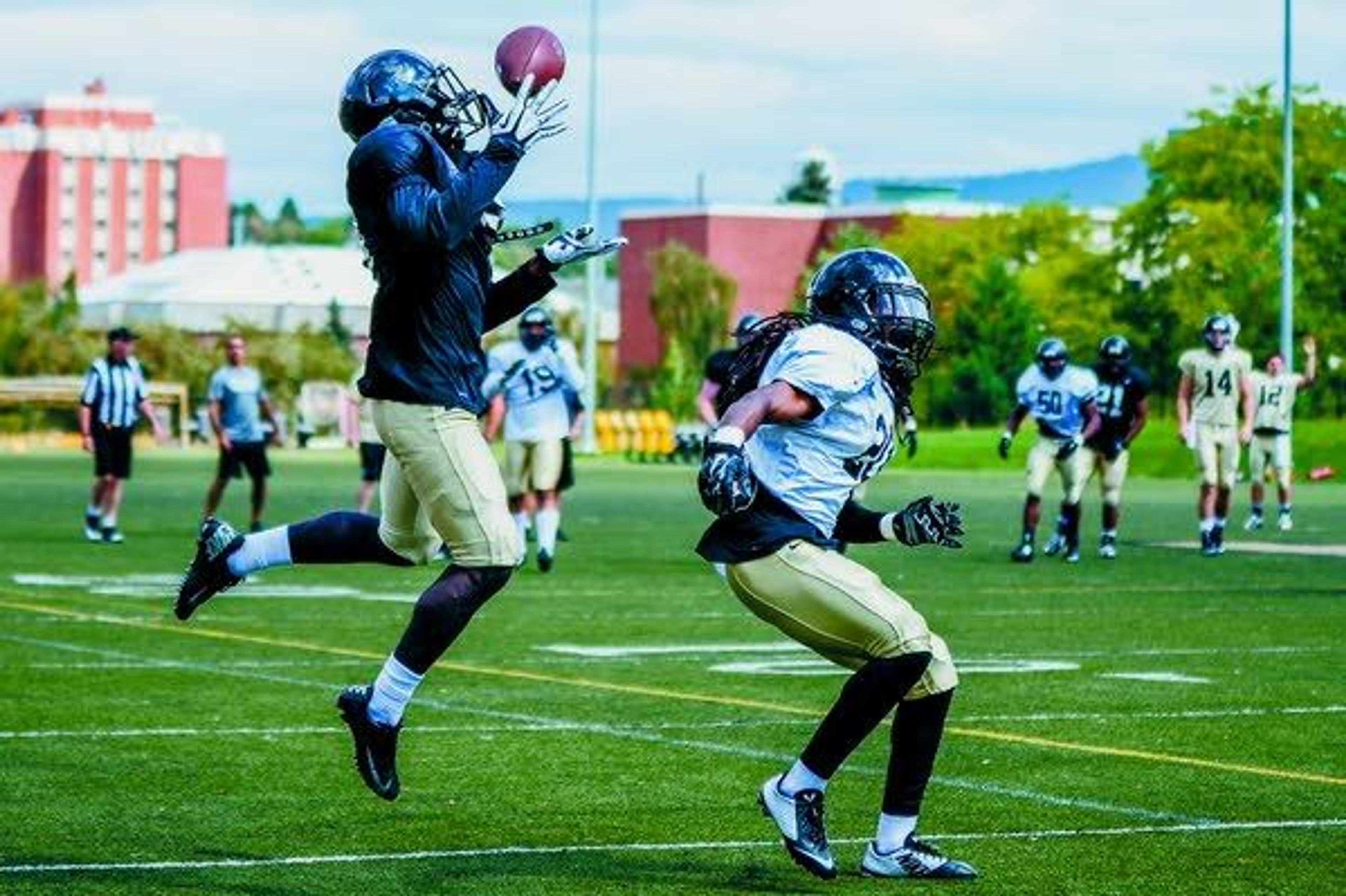 Idaho wide receiver Jante Boston, left, jumps to catch a touchdown pass over cornerback Dorian Clark during a scrimmage Saturday in Moscow.