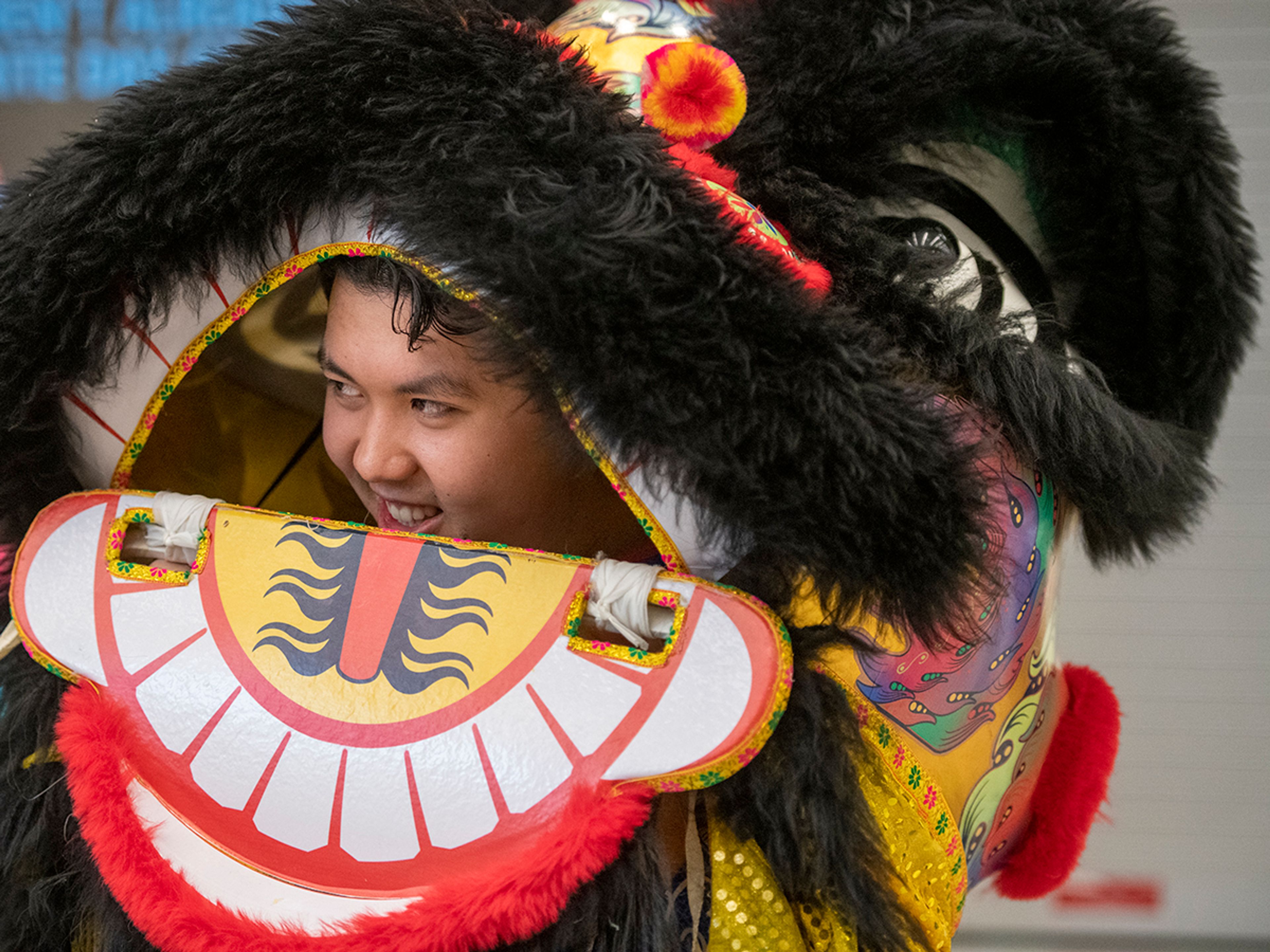 Ricky Ha pokes his head out of a Vietnamese lion costume Friday at Pullman High School’s multicultural night.