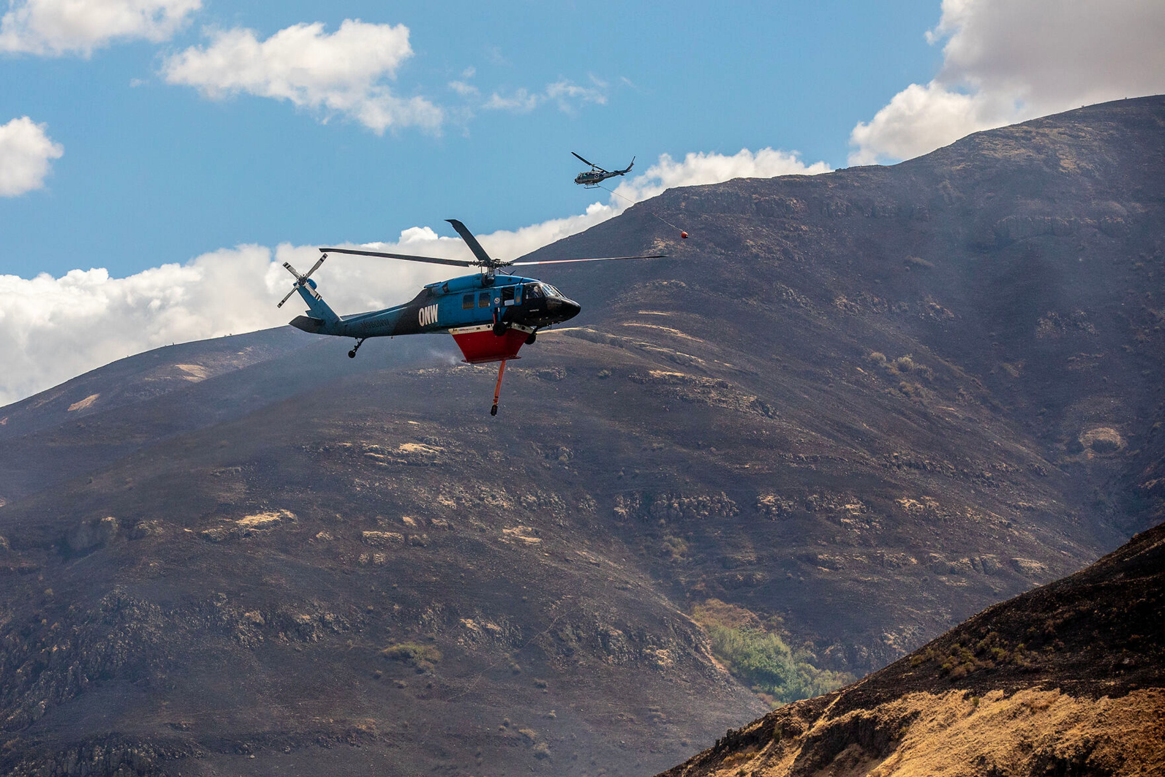 Helicopters pass by as they fill up in the Snake River at the Lower Granite Fire Tuesday.