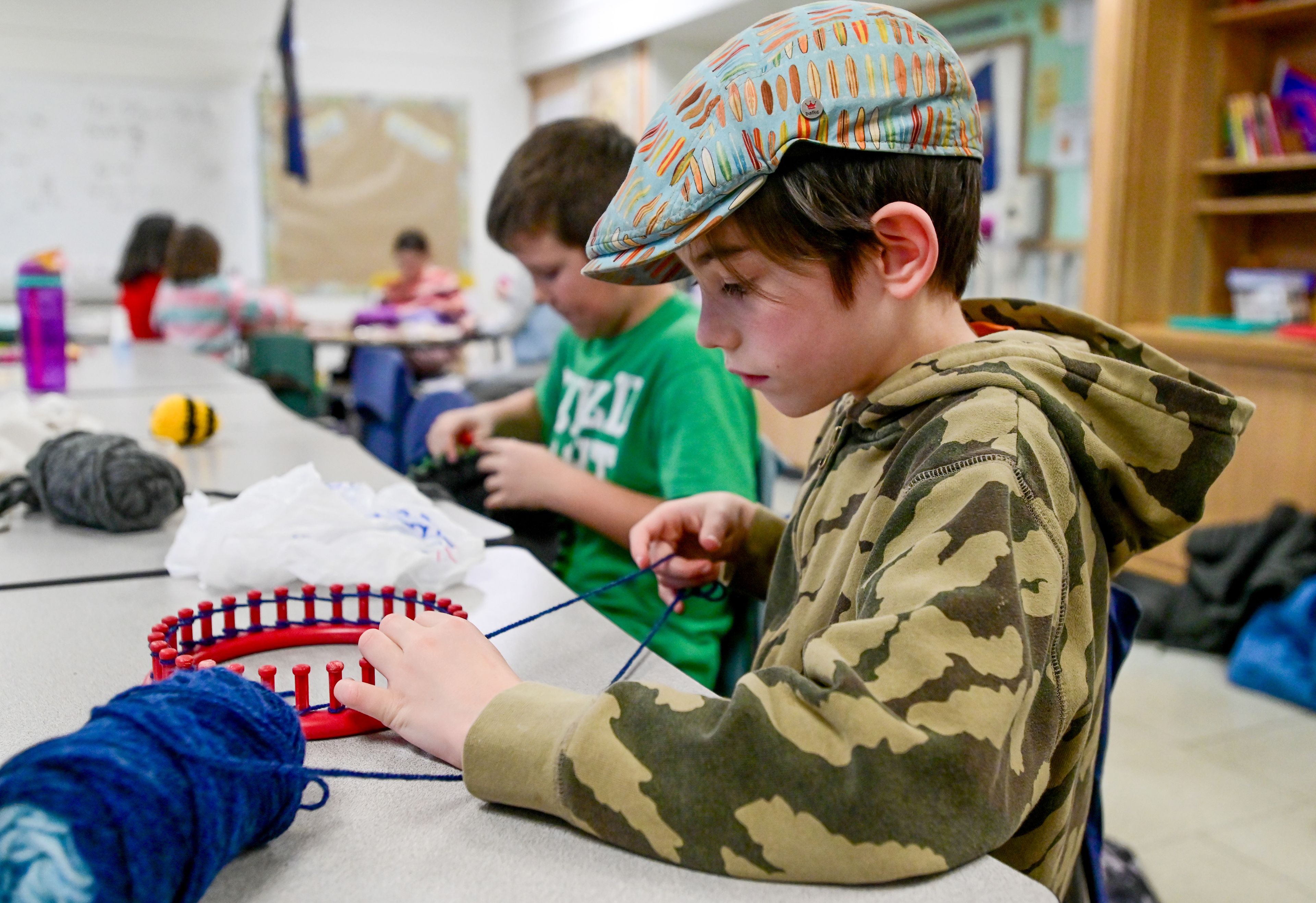 Second-grader Henry Turpin starts a new hat on a round loom after school at Lena Whitmore Elementary School in Moscow on Monday.