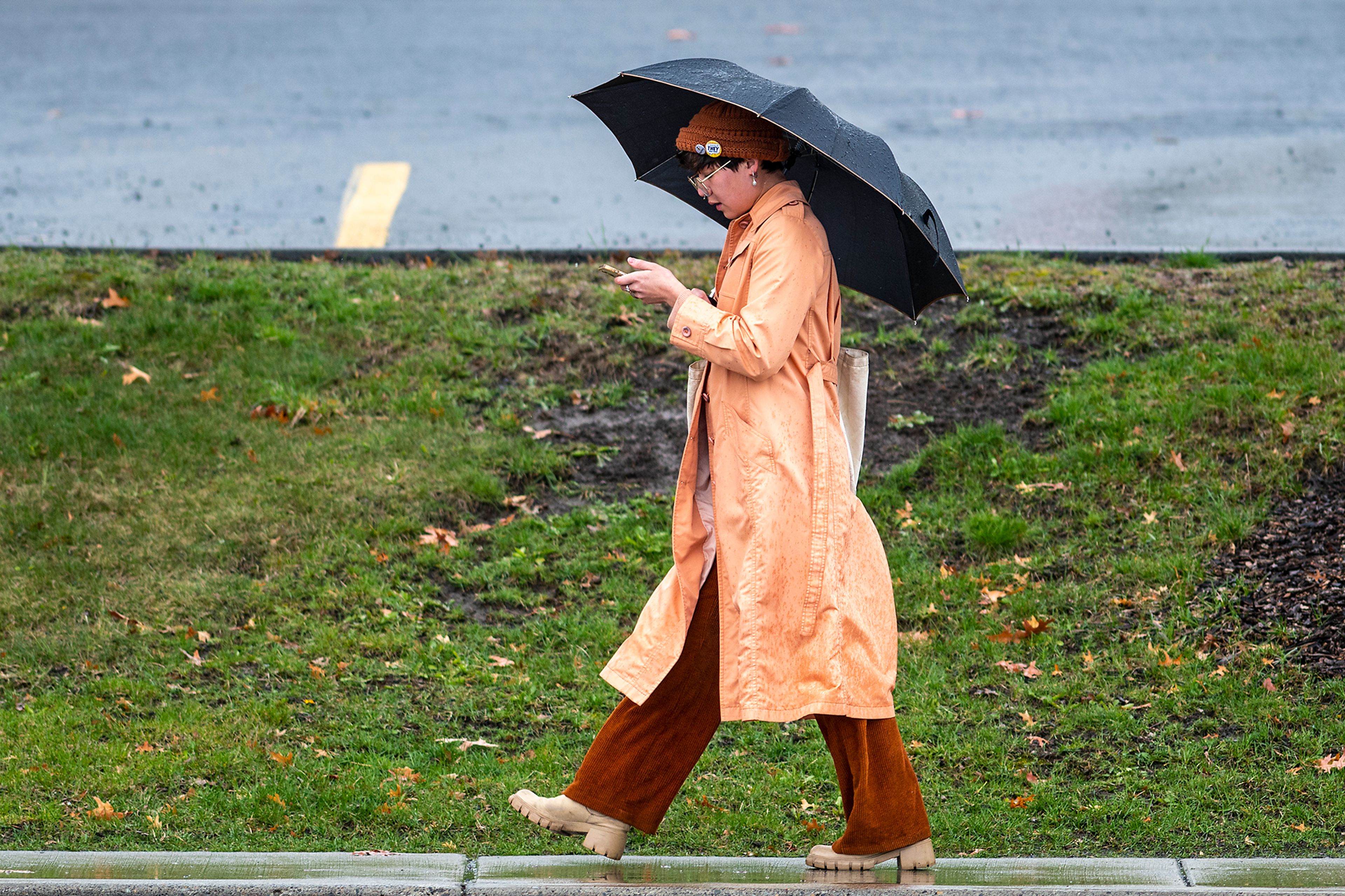 Photos by Zach Wilkinson/Daily News ABOVE: A pedestrian texts underneath an umbrella Monday while walking through heavy rainfall and high winds along Sweet Avenue in Moscow. LEFT: A pedestrian loses partial visibility Monday as gusts of wind blow hair in front of her eyes while crossing the road at the corner of Sixth and Main streets in Moscow. BELOW: A man searches for his tee shot while holding his hat against high gusts of wind and heavy rainfall Monday while playing a round of golf at the University of Idaho golf course in Moscow.