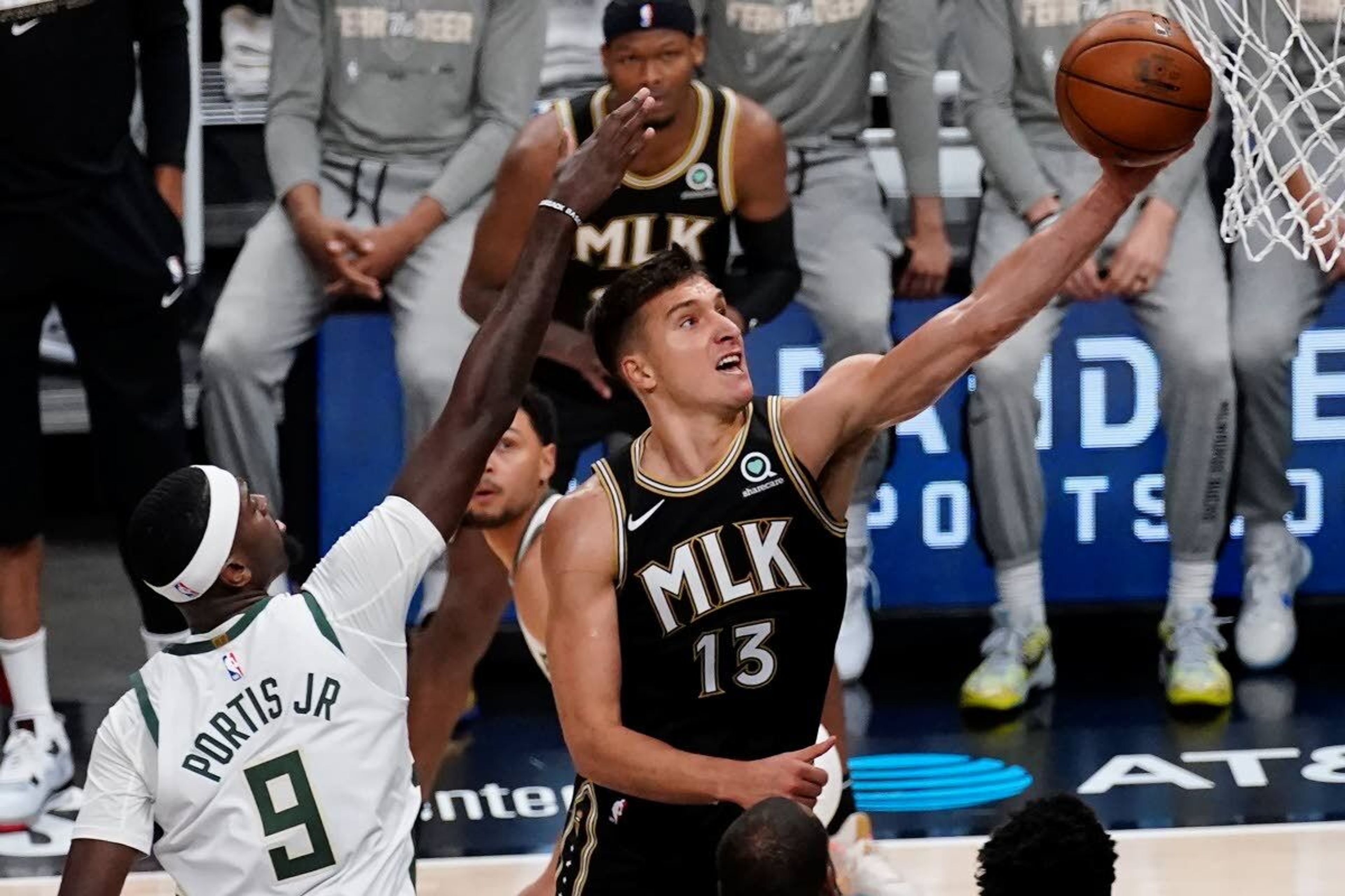 Atlanta Hawks guard Bogdan Bogdanovic (13) shoots next to Milwaukee Bucks center Bobby Portis (9) during the first half of Game 6 in the NBA basketball playoffs Eastern Conference finals Saturday, July 3, 2021, in Atlanta. (AP Photo/John Bazemore)