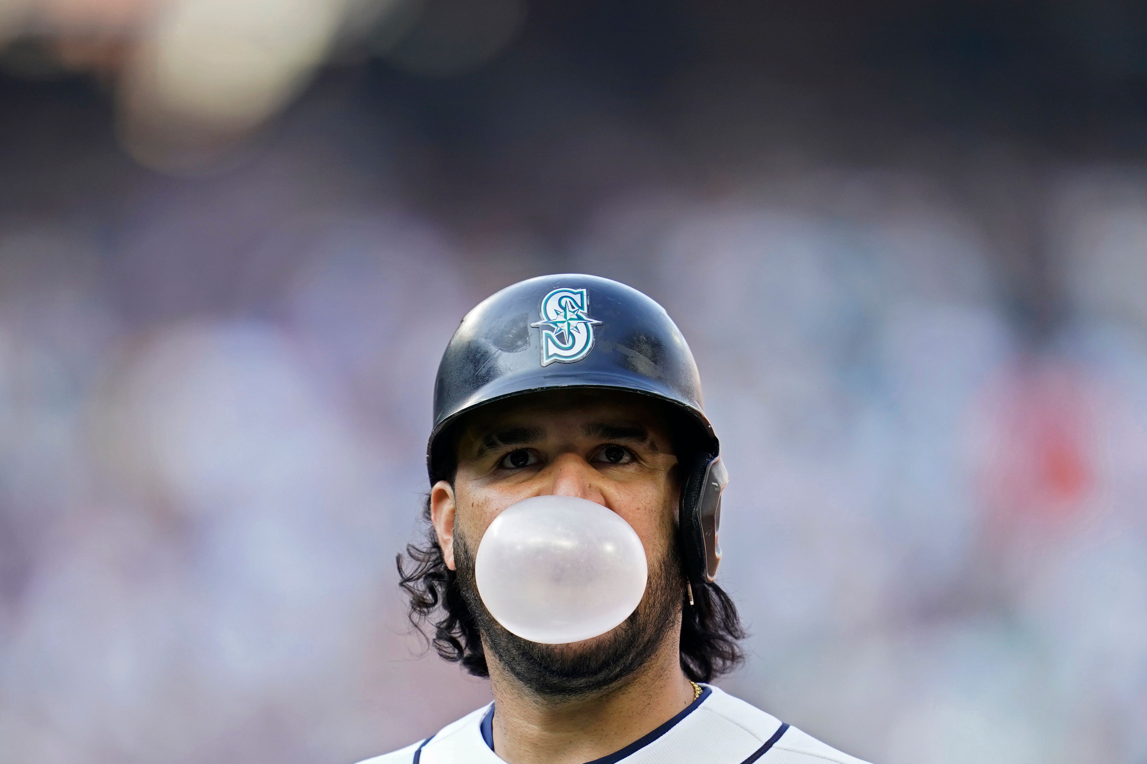 Seattle Mariners third baseman Eugenio Suarez (28) blows a bubble after hitting a fly ball for an out against the Houston Astros during the sixth inning in Game 3 of an American League Division Series baseball game Saturday, Oct. 15, 2022, in Seattle. (AP Photo/Abbie Parr)