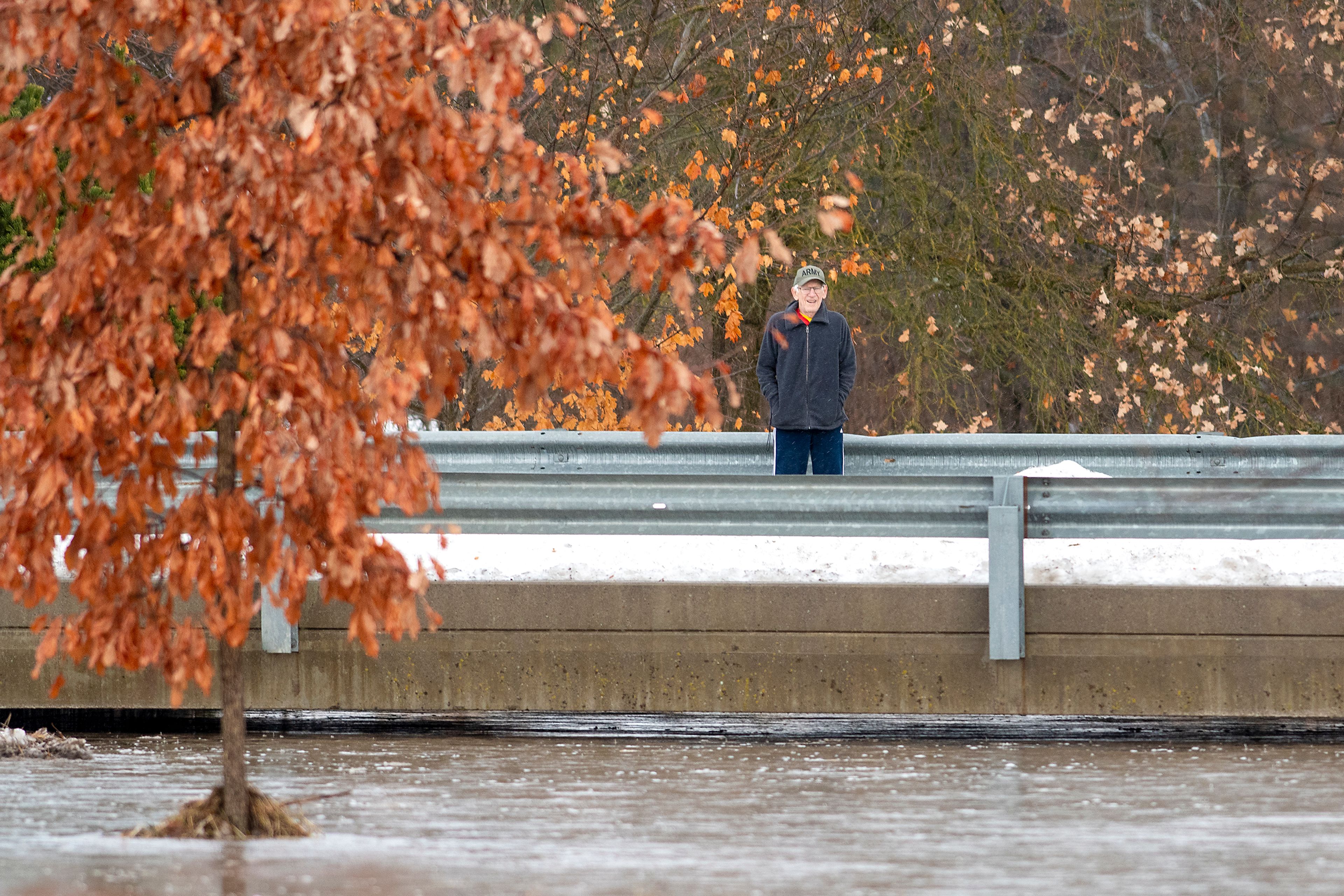 A pedestrian examines a flooding Paradise Creek on Tuesday from a bridge on Eisenhower Street in Moscow.