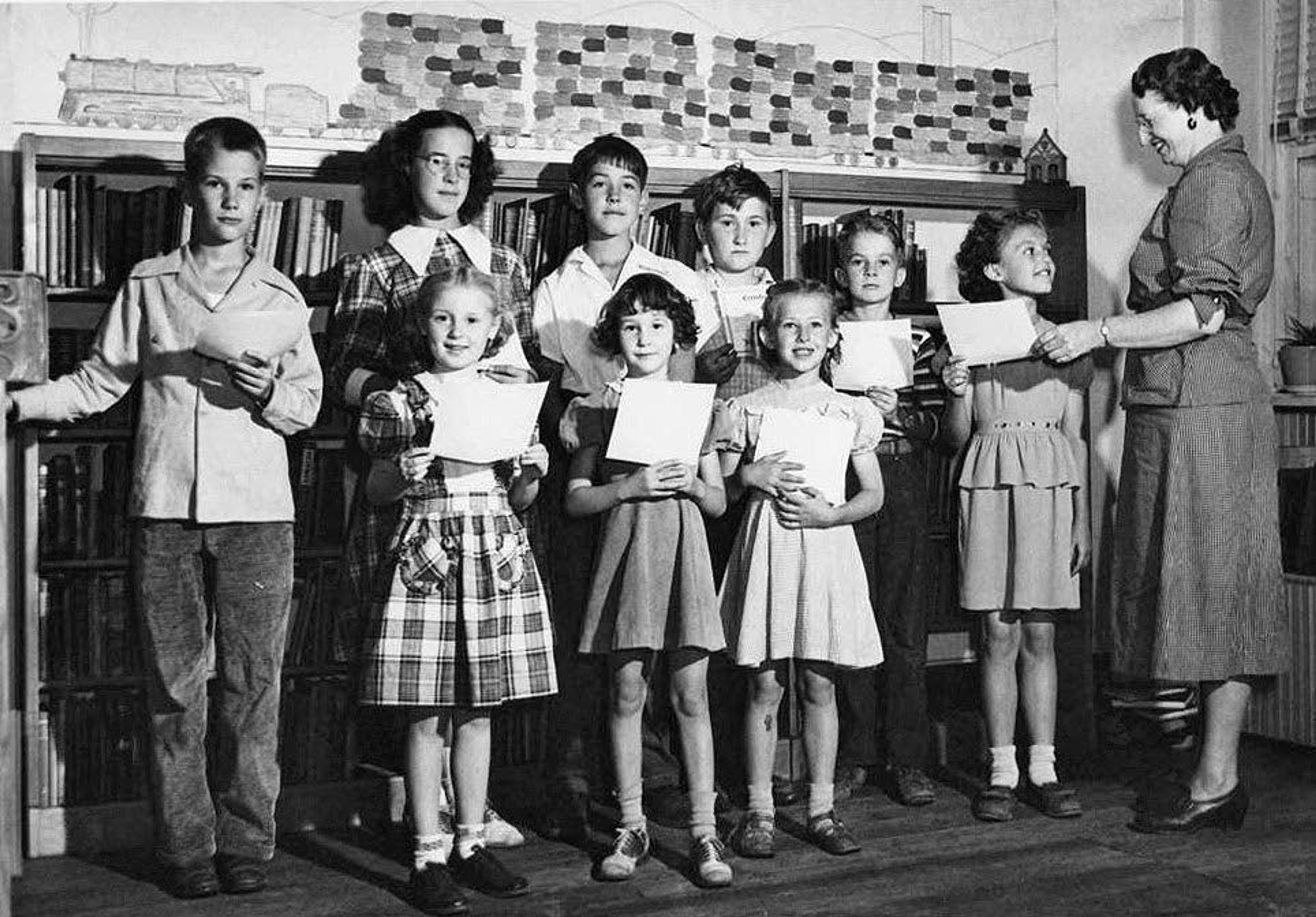 Gladys Bowles, Whitman County Librarian, presents reading club certificates to children for participation in the summer reading program called World Friendship Vacation Reading Club in 1948. Bowles was the director of the Whitman County Rural Library District when it was formed in 1945.